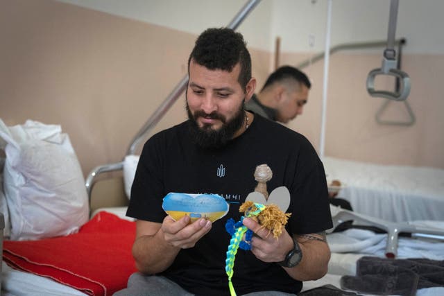 <p>Russia Ukraine A wounded professional soldier from Medellín, Colombia who goes by the call sign of Checho, 32, smiles as he holds gifts</p>