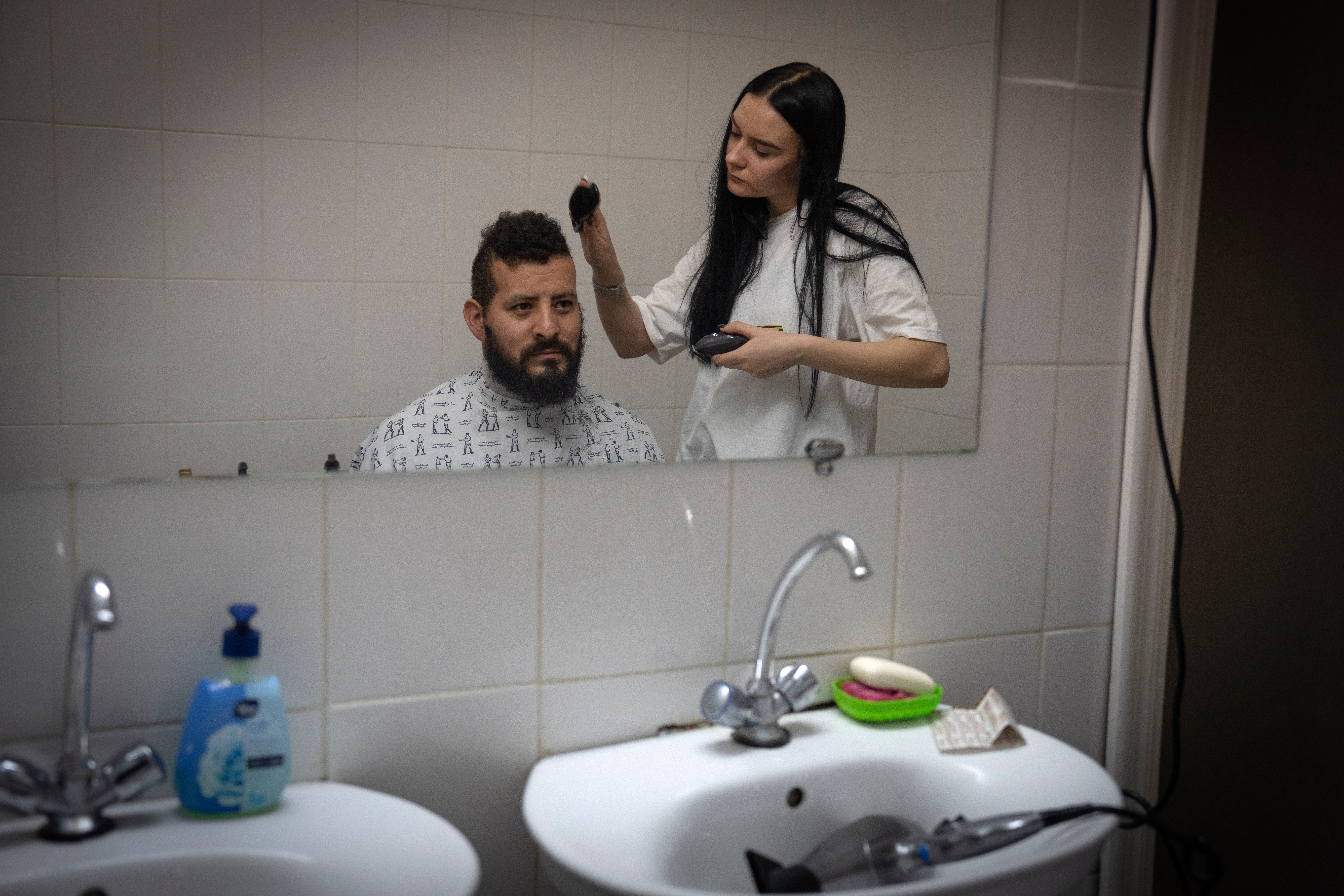 A barber cuts the hair of Checho, 32, a wounded professional soldier from Medellín, Colombia, in a hospital in Ukraine