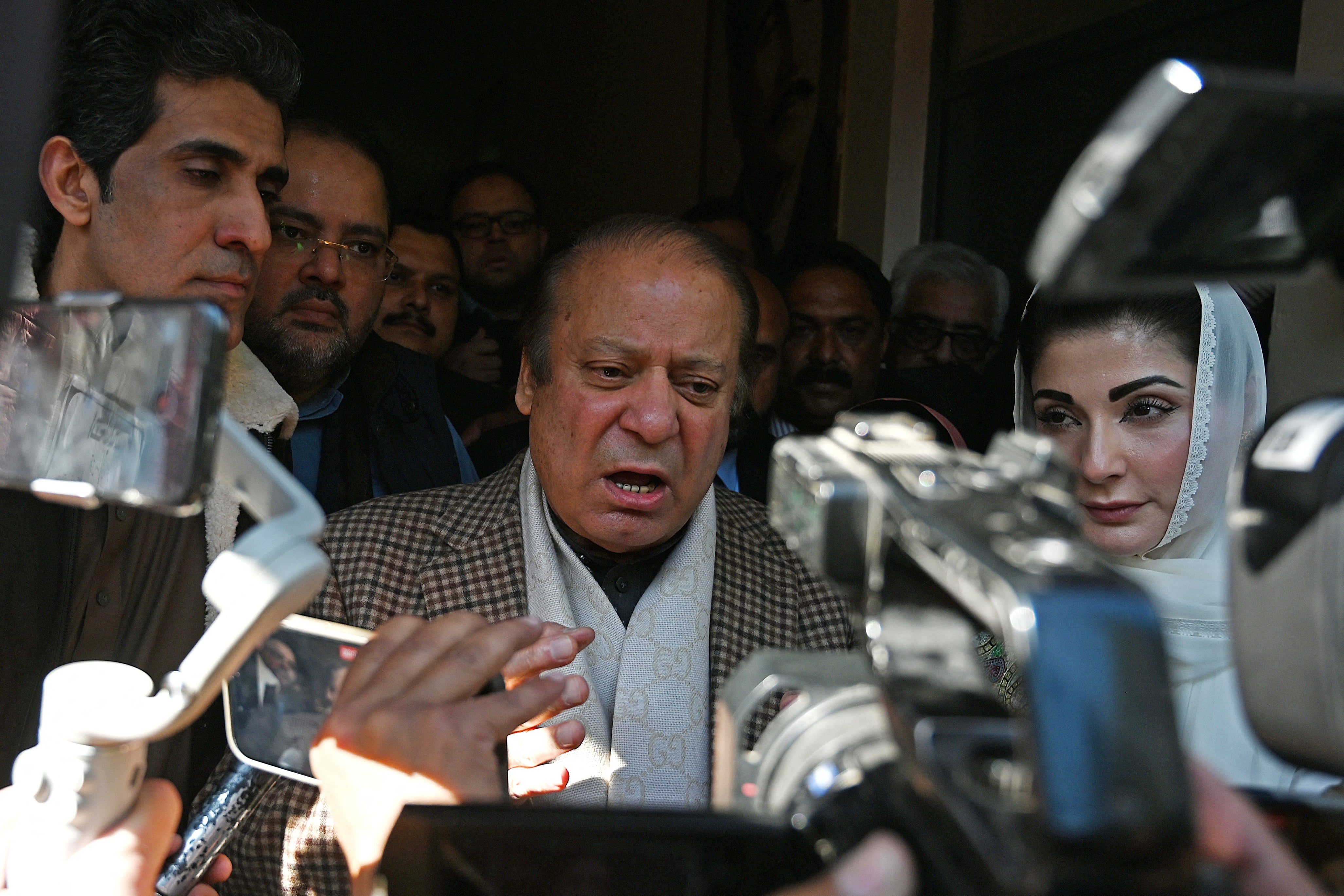 Pakistan's former Prime Minister and leader of the Pakistan Muslim League-Nawaz (PML-N) Nawaz Sharif (C) along with his daughter Maryam Nawaz (R) speaks to media after casting his ballot to vote