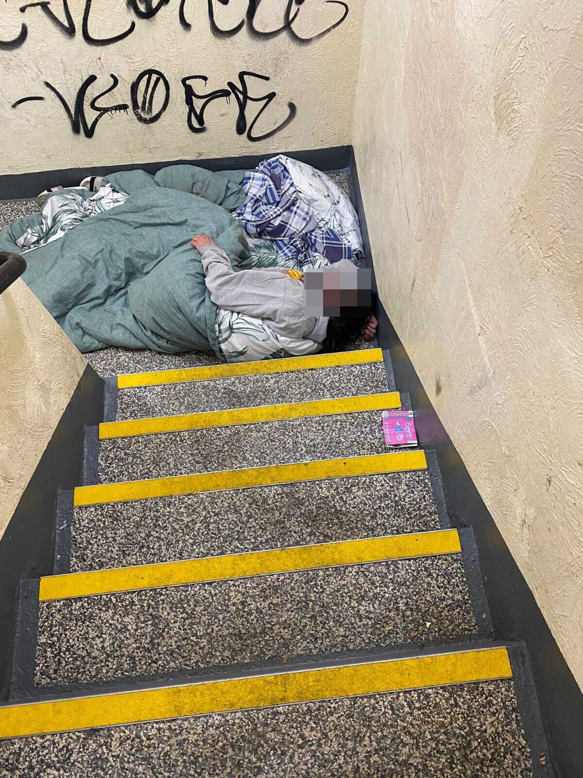 A person sleeping in the stairwell of Milford Towers