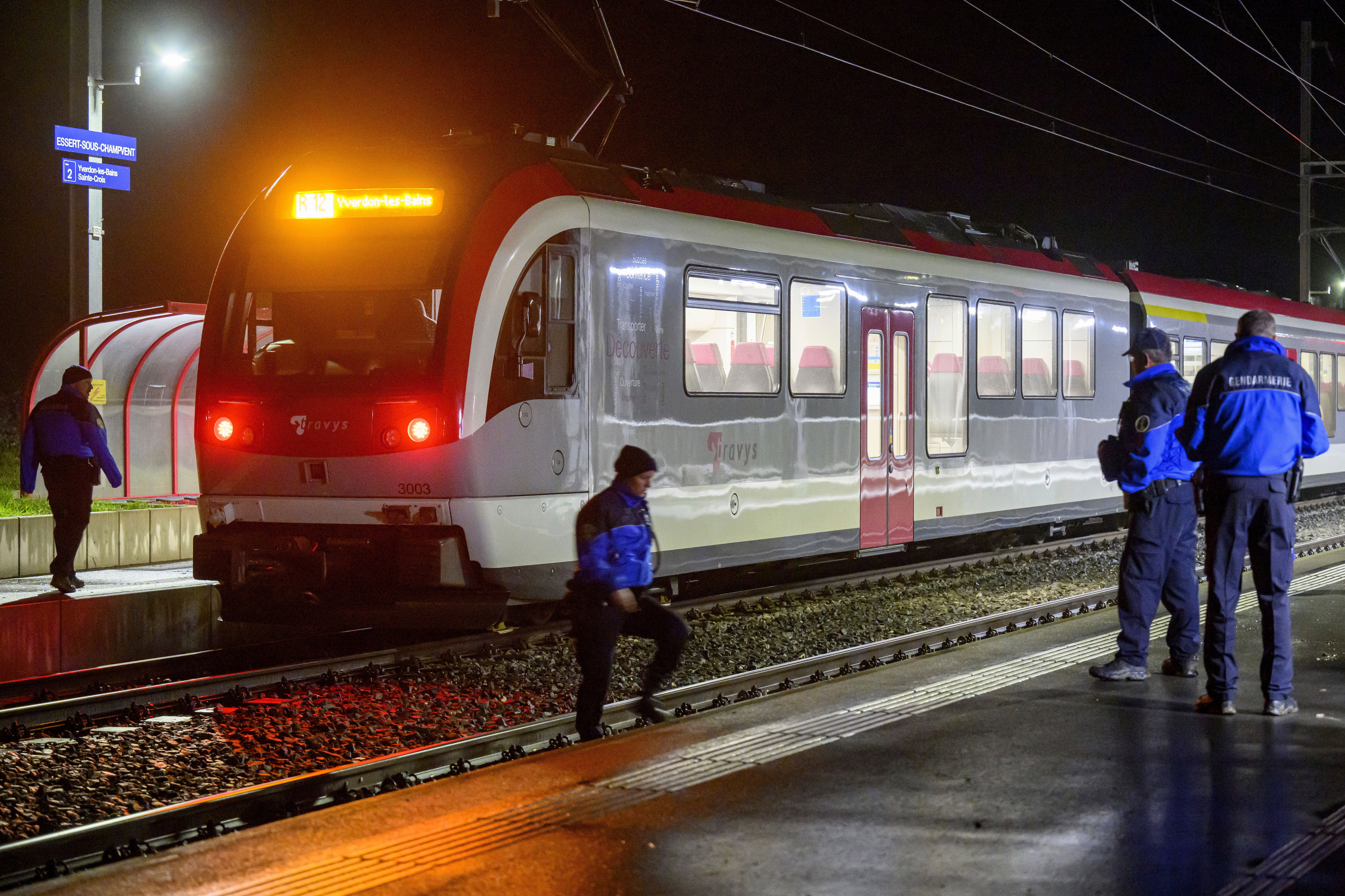 Vaud cantonal police officers watch the Travys train where a hostage-taking incident took place at Essert-sous-Champvent...