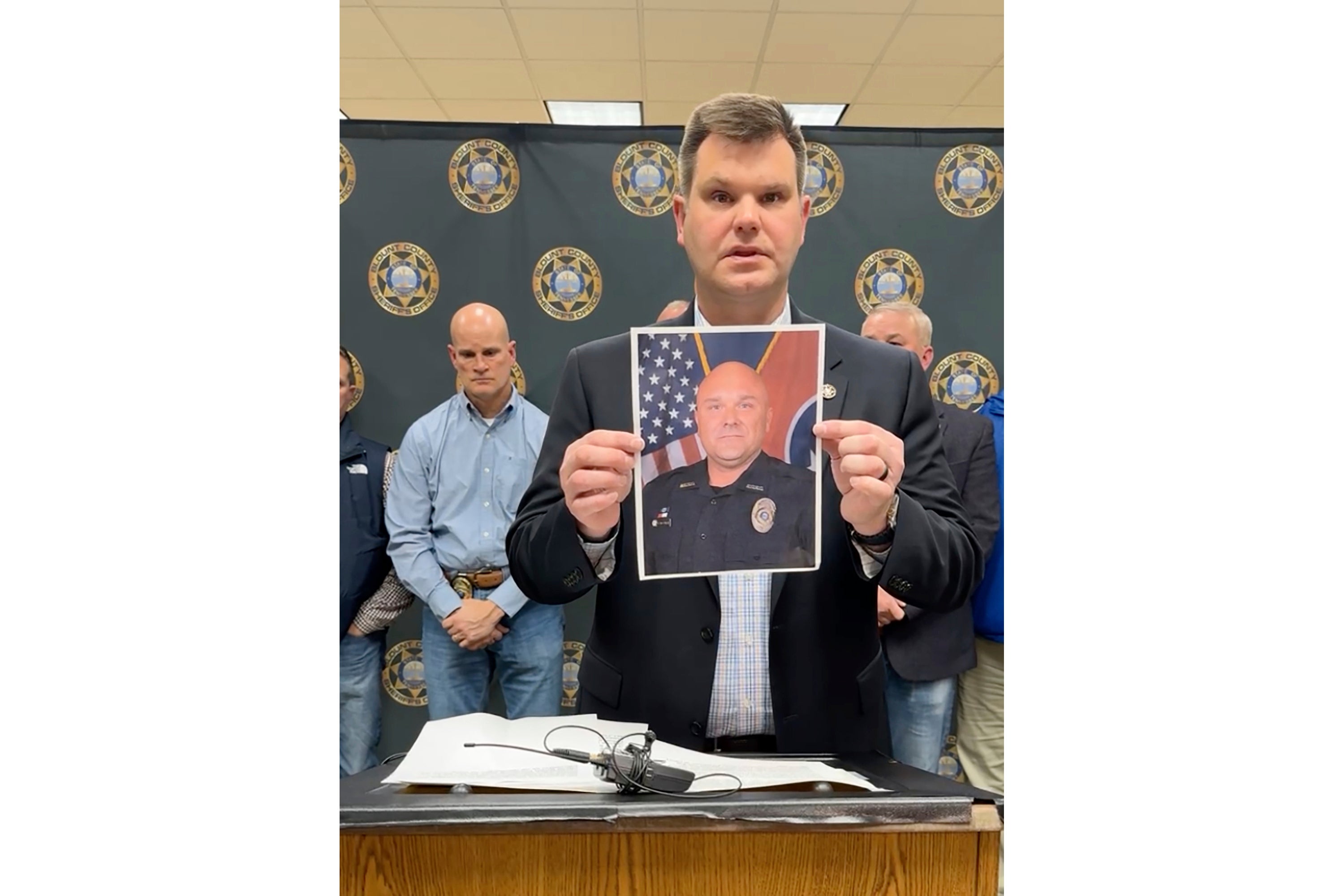An official shows a picture of the killed deputy, Greg McCowan, during a press conference