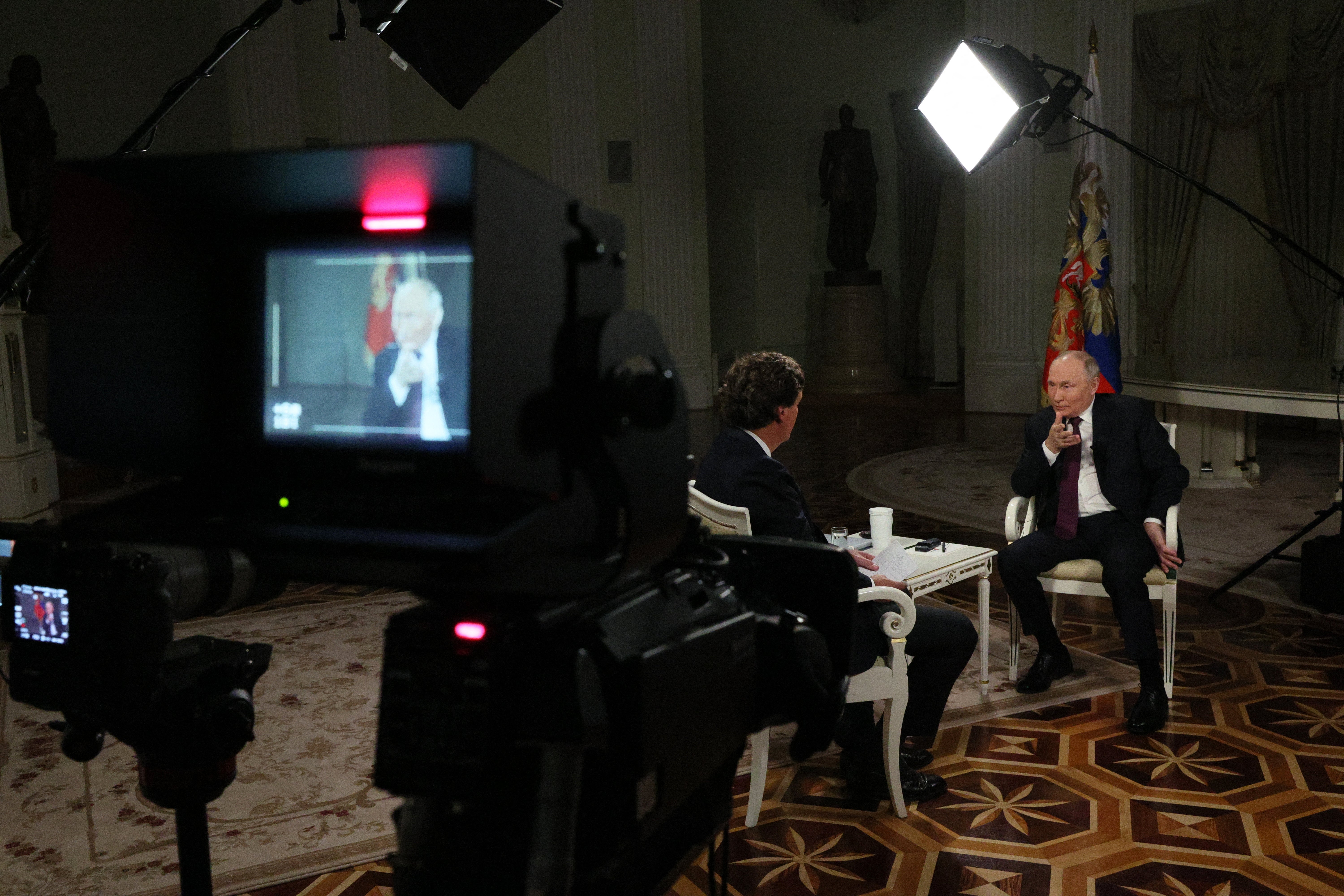 In this pool photograph distributed by Russian state agency Sputnik, Russia's President Vladimir Putin gives an interview to US talk show host Tucker Carlson at the Kremlin in Moscow on February 6, 2024