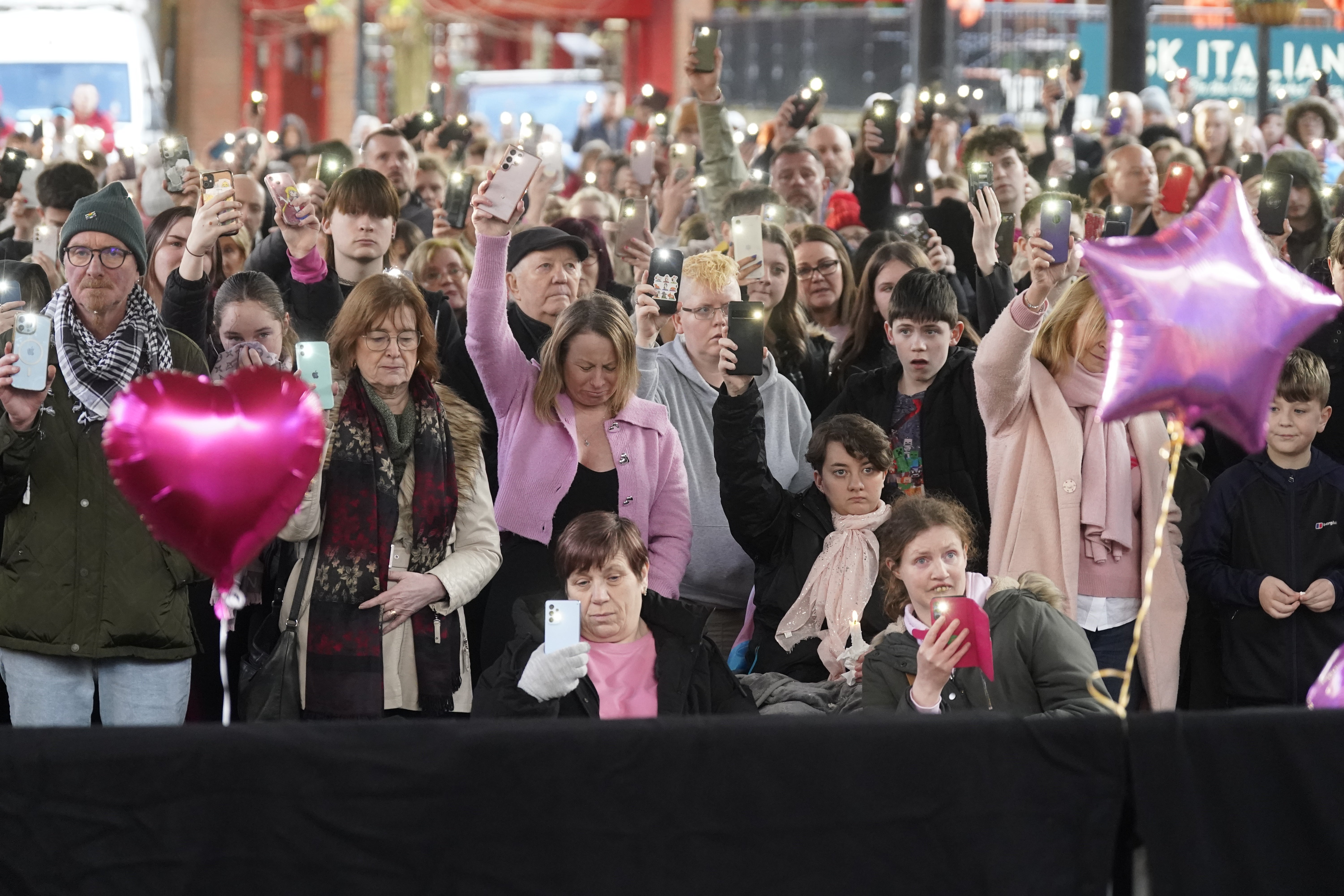 People holding their phones aloft during a two minutes silence at the vigil