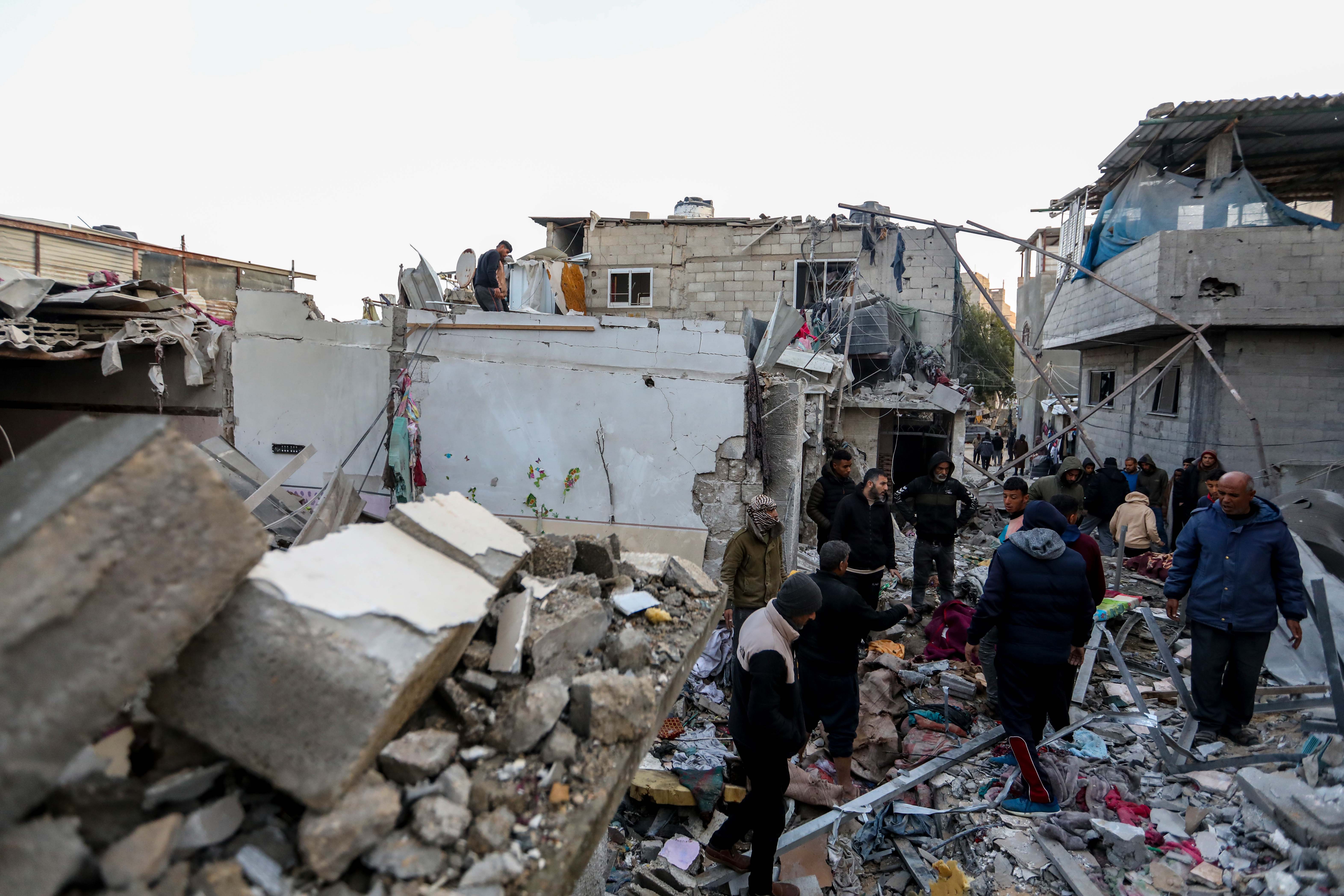 People inspect the damage to their homes in Rafah following Israeli air strikes