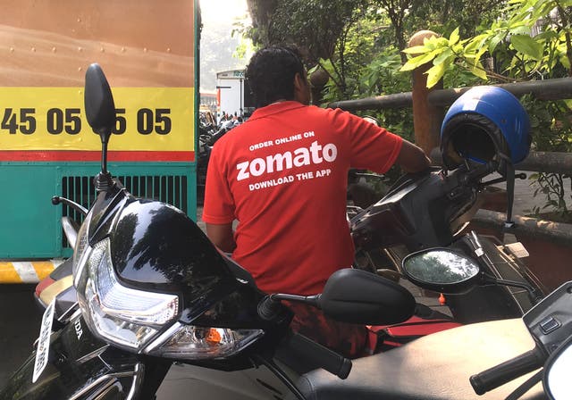 <p>In this photo taken on 24 December 2018, an Indian delivery man working with the food delivery app Zomato sits on his bike in a business district in Mumbai</p>