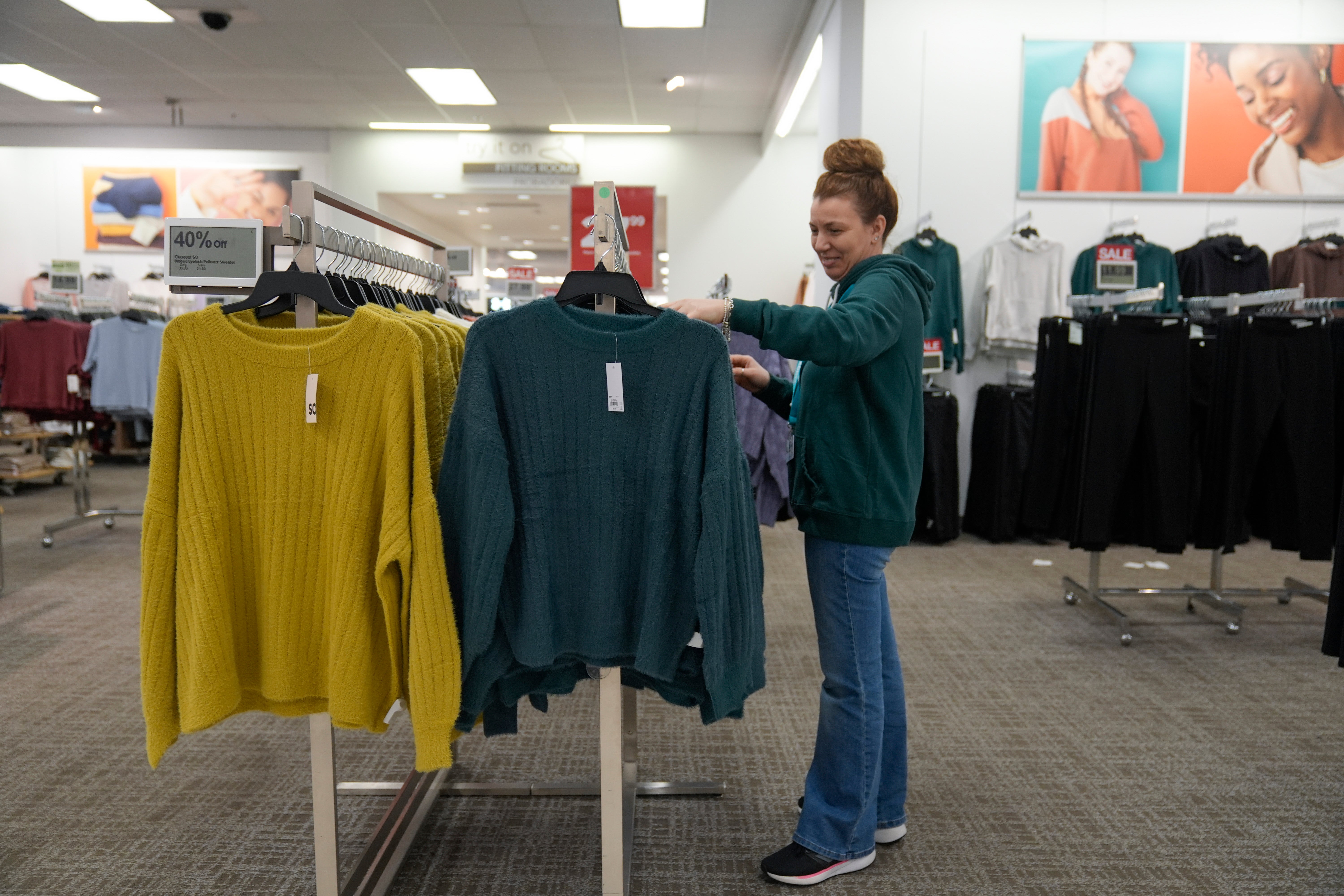 An employee straightens displays at a Kohl’s store in Clifton