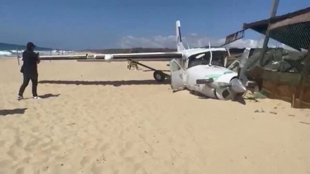 <p>A person stands near the wreckage of a small plane that crashed into a sea turtle preservation site at Bacocho beach, in Oaxaca state</p>