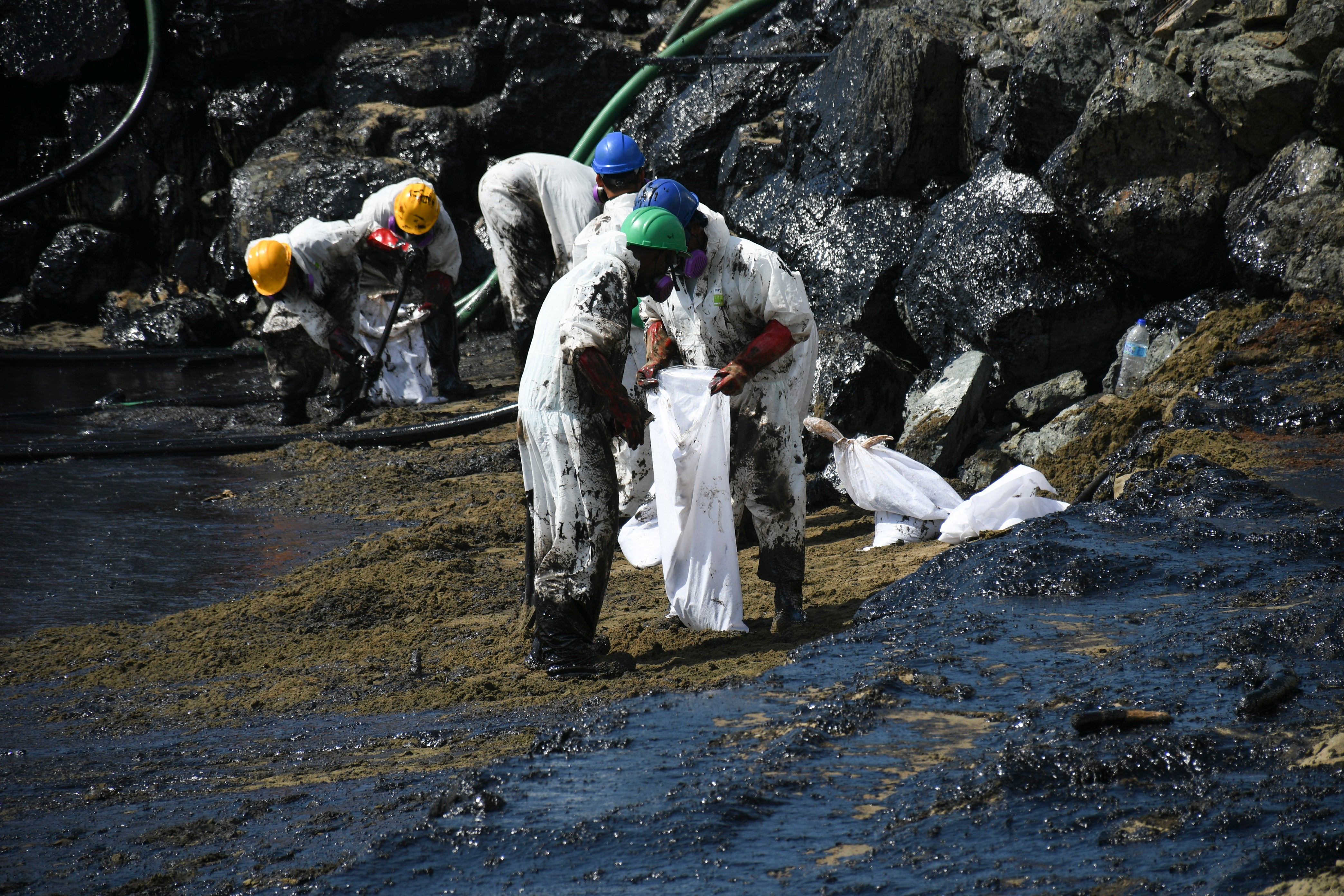 Workers from state own Heritage Petroleum Oil and Gas Company clean up an oil spill that reached Rockly Bay beach, in Scarborough, south western Tobago, Trinidad and Tobago