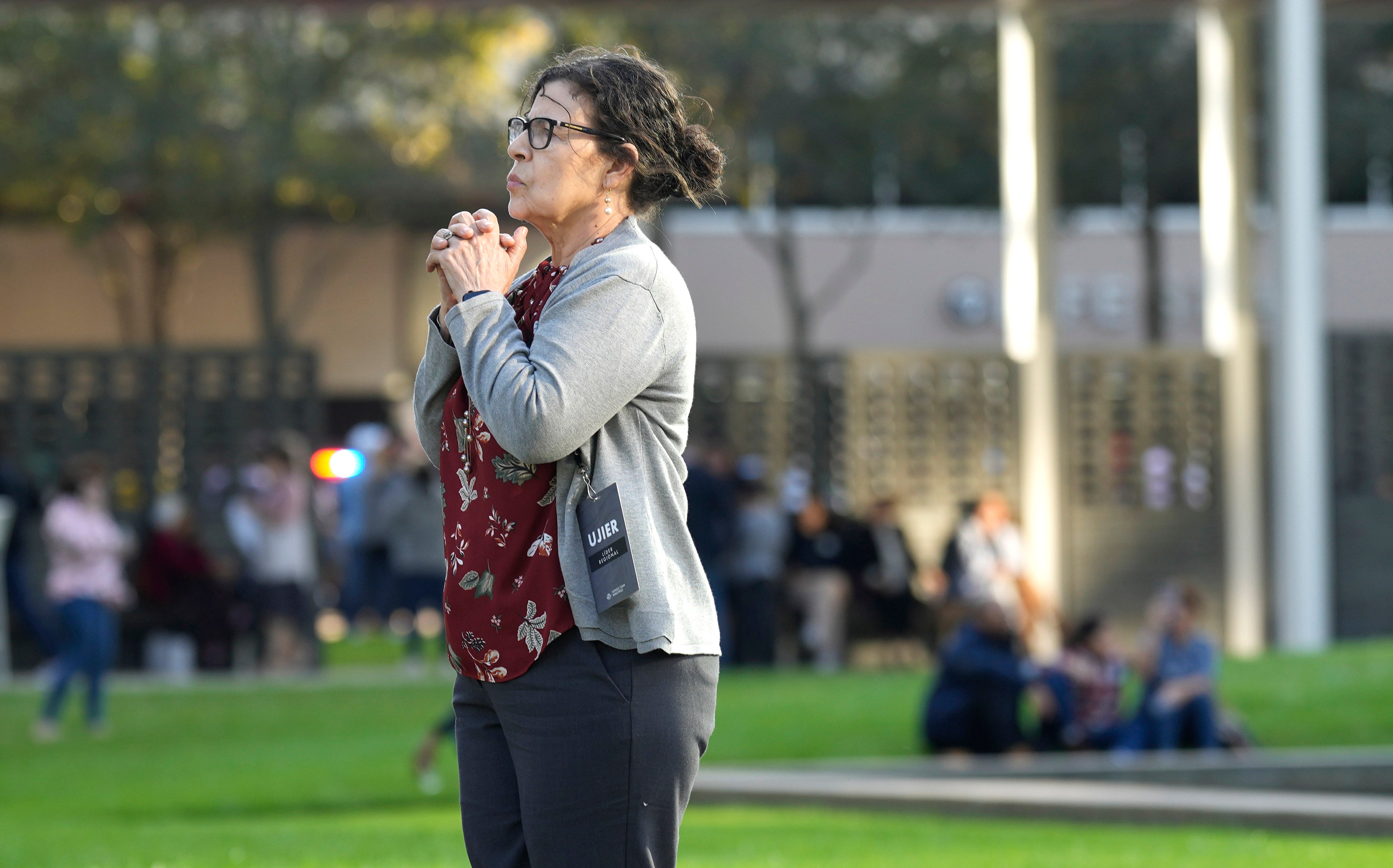 A woman stands outside Lakewood Church after a shooting during a Spanish church service