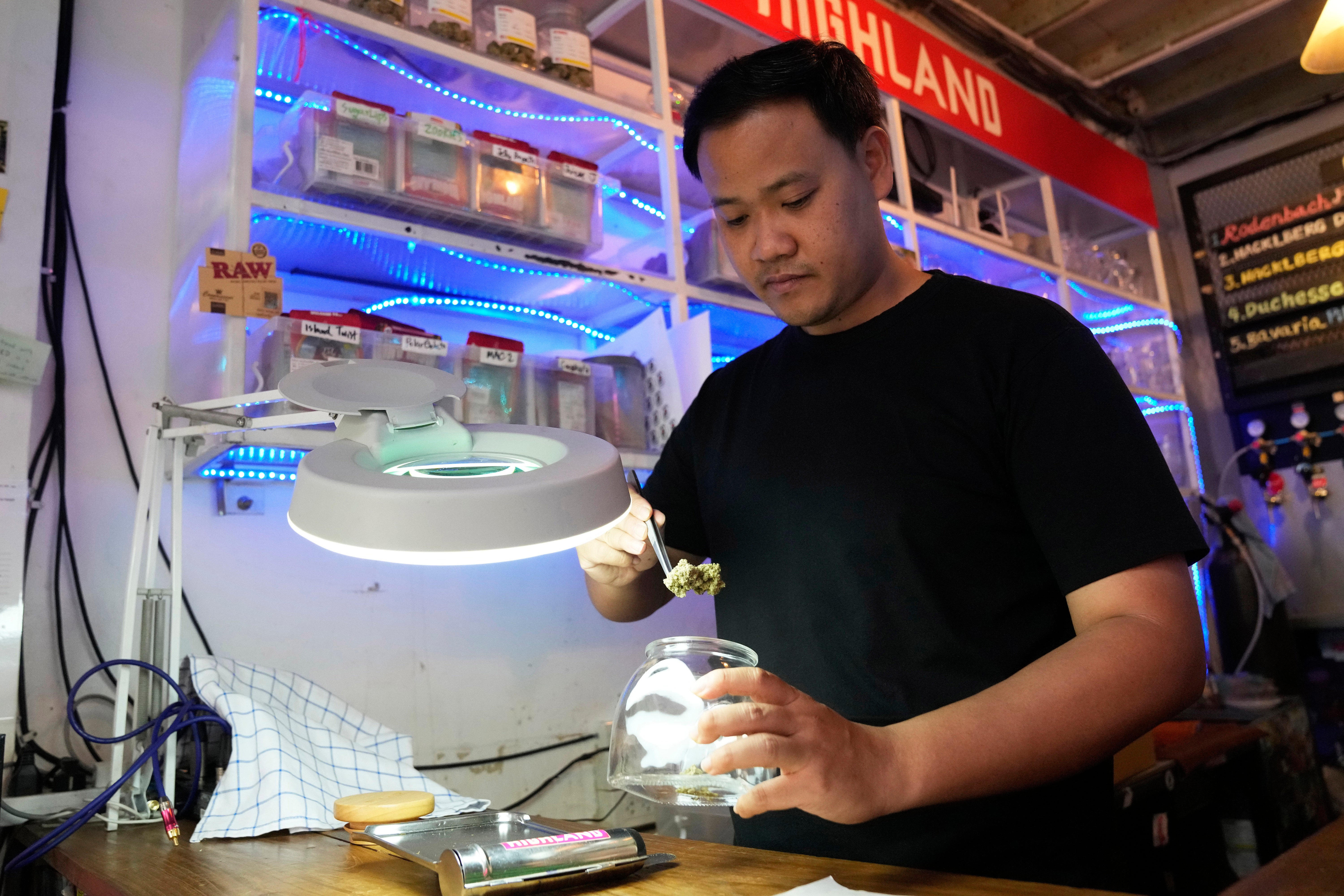 Founder of Highland cafe Rattapon Sanrak prepares flower bud of marijuana for customers at his shop in Bangkok, Thailand