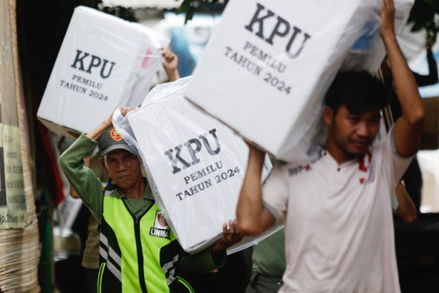 <p> Electoral officers carry ballot boxes during distribution of materials to polling stations ahead of voting day in Depok, Indonesia, 13 February 2024</p>