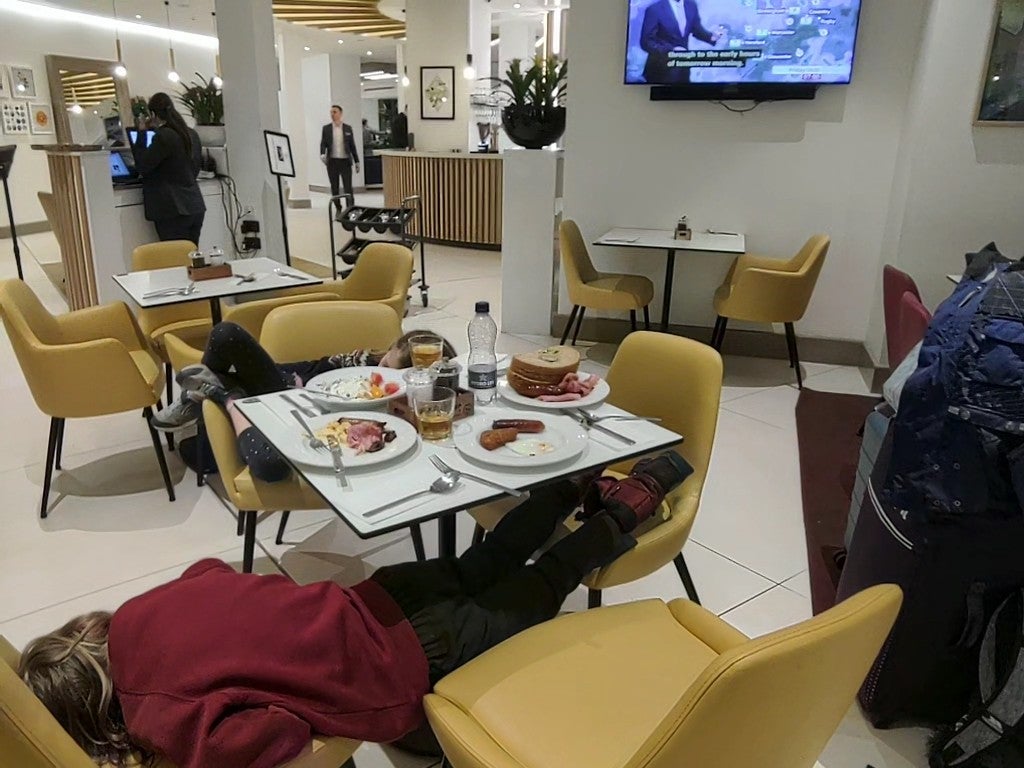 Children exhausted by the wait for an update on the cancelled EasyJet flight sleep at a breakfast restaurant