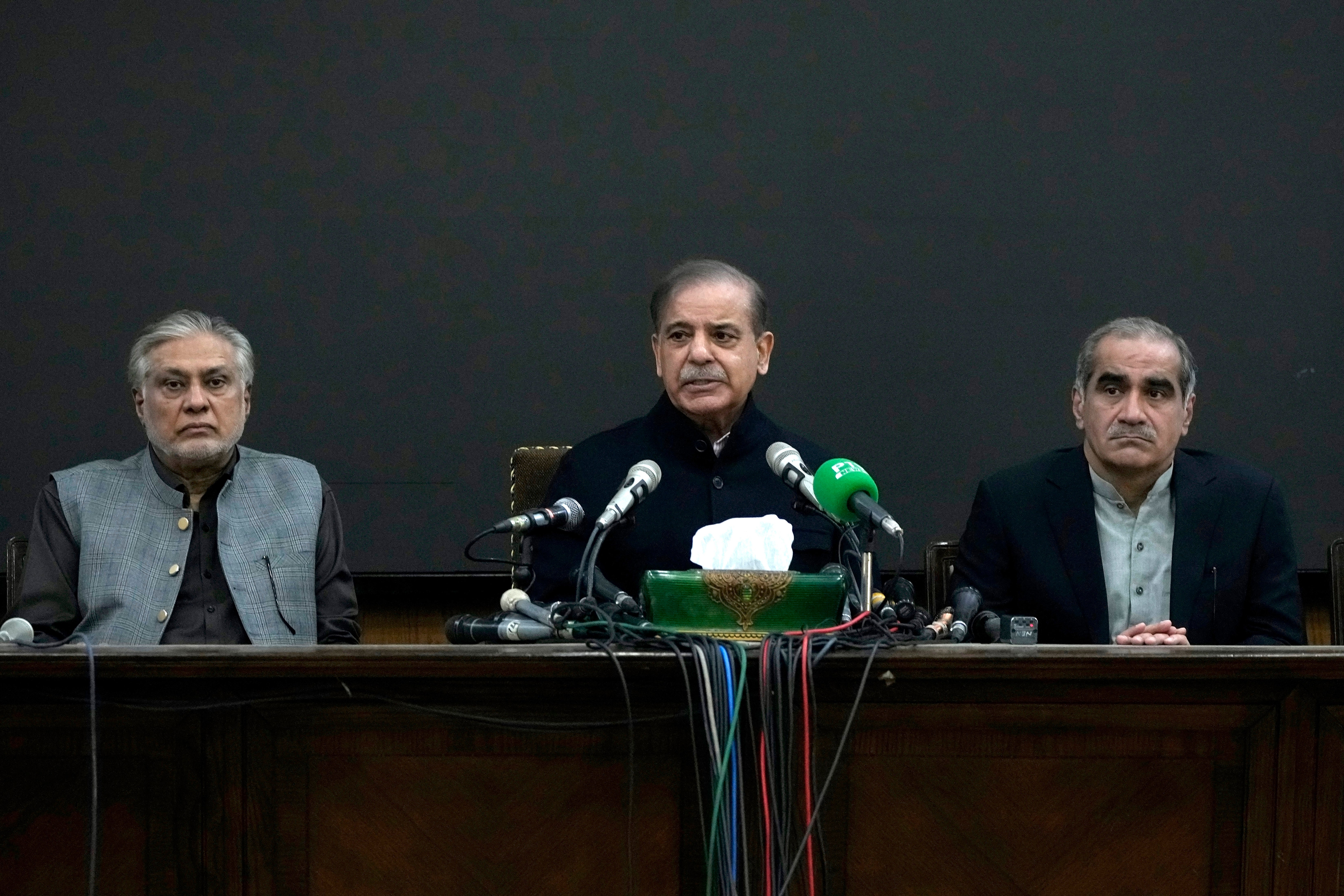 Pakistan's former Prime Minister Shehbaz Sharif, center speaks as his party aids Ishaq Dar, left, and Khawaja Saad Rafiq watch during a press conference regarding parliamentary elections, in Lahore, Pakistan