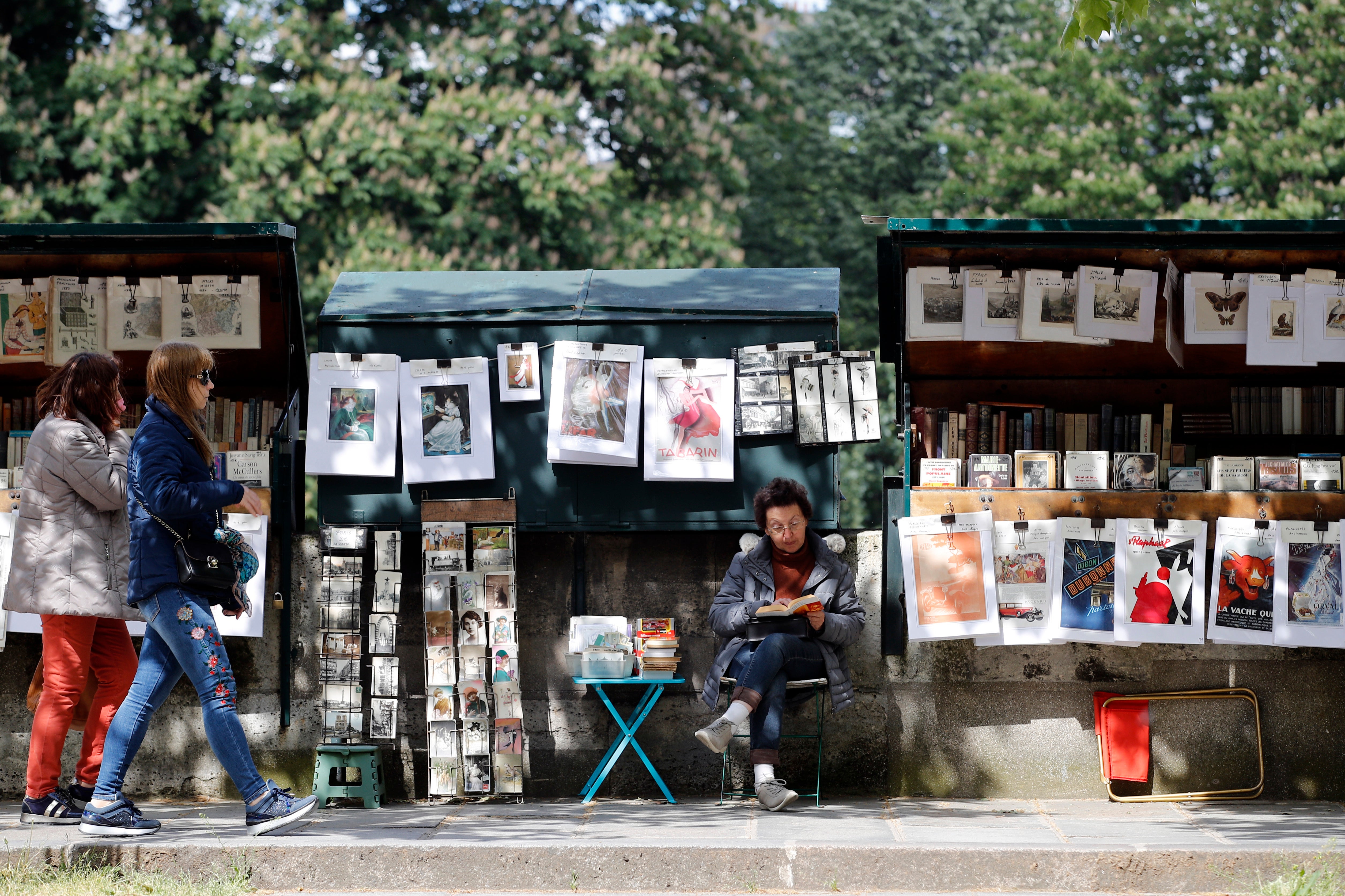 Visitors walk past a bookseller of used and antiquarian books called “Bouquiniste”, in Paris