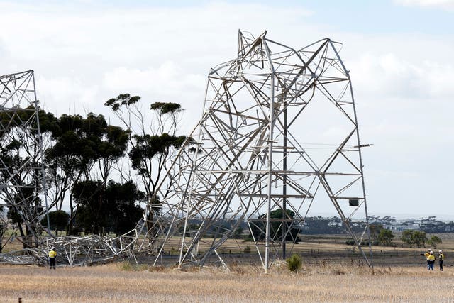 <p>Workers inspect damaged electricity transmission towers on the outskirts of Melbourne, Australia</p>