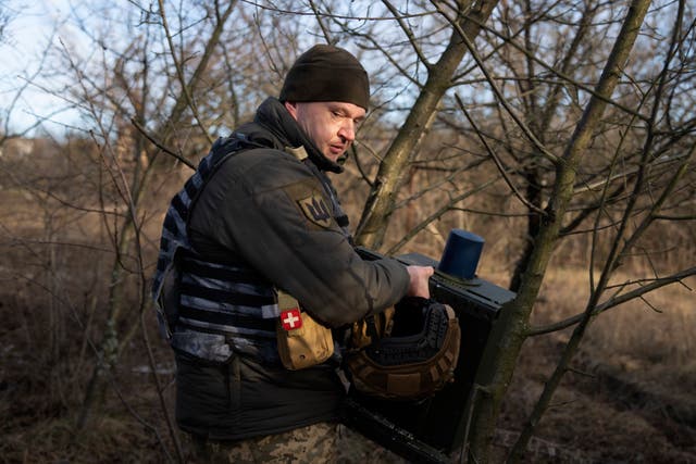 <p>A Ukrainian soldier installs an electronic warfare system to quell Russian drones at the front line, near Bakhmut</p>
