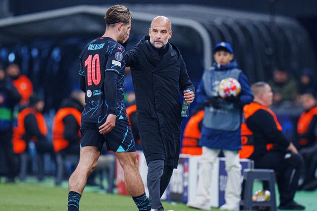 <p>Manchester City’s Jack Grealish, left, is substituted and given a pat by manager Pep Guardiola in Denmark (Liselotte Sabroe/Ritzau Scanpix via AP)</p>