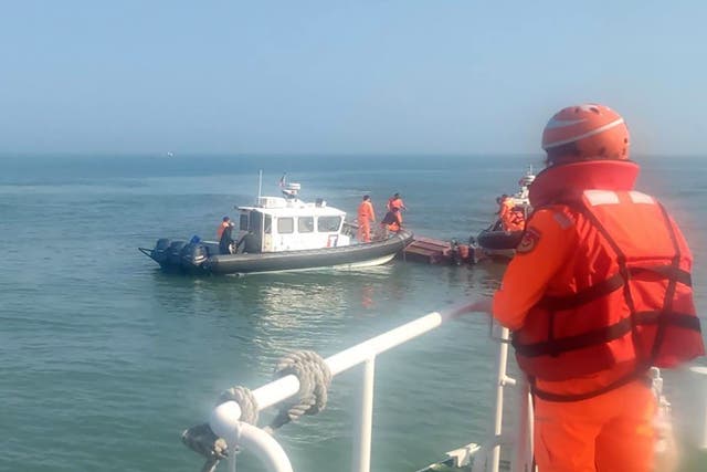 <p>In this handout photograph provided by Taiwan Coast Guard Administration, Taiwanese coast guards inspect a vessel that capsized during a chase off the coast of Kinmen archipelago in Taiwan, Wednesday, 14 February 2024</p>