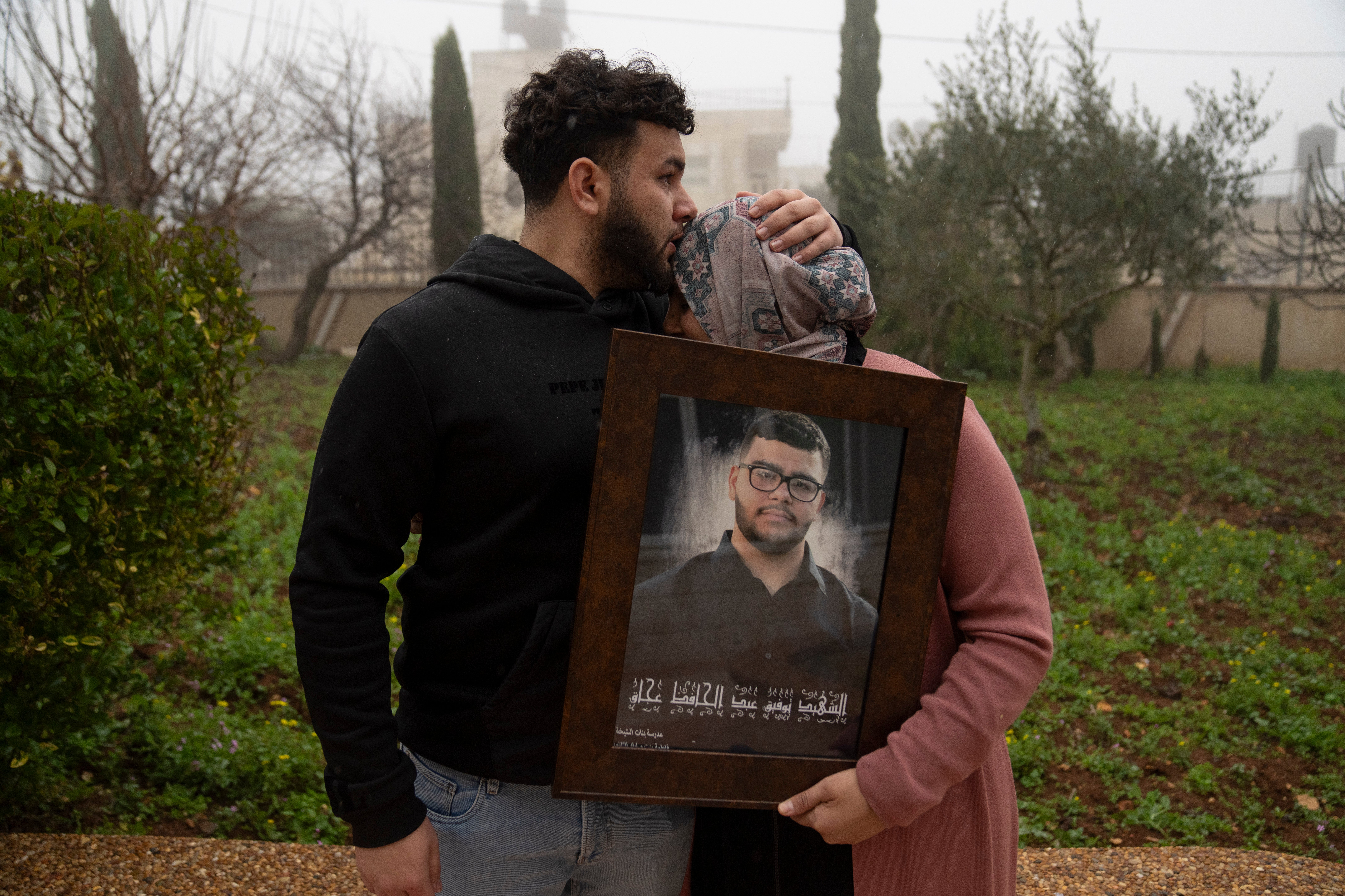 Amir Abdel Jabbar, whose younger brother Tawfic was fatally shot in the West Bank, comforts their mother, Mona, on 23 January.