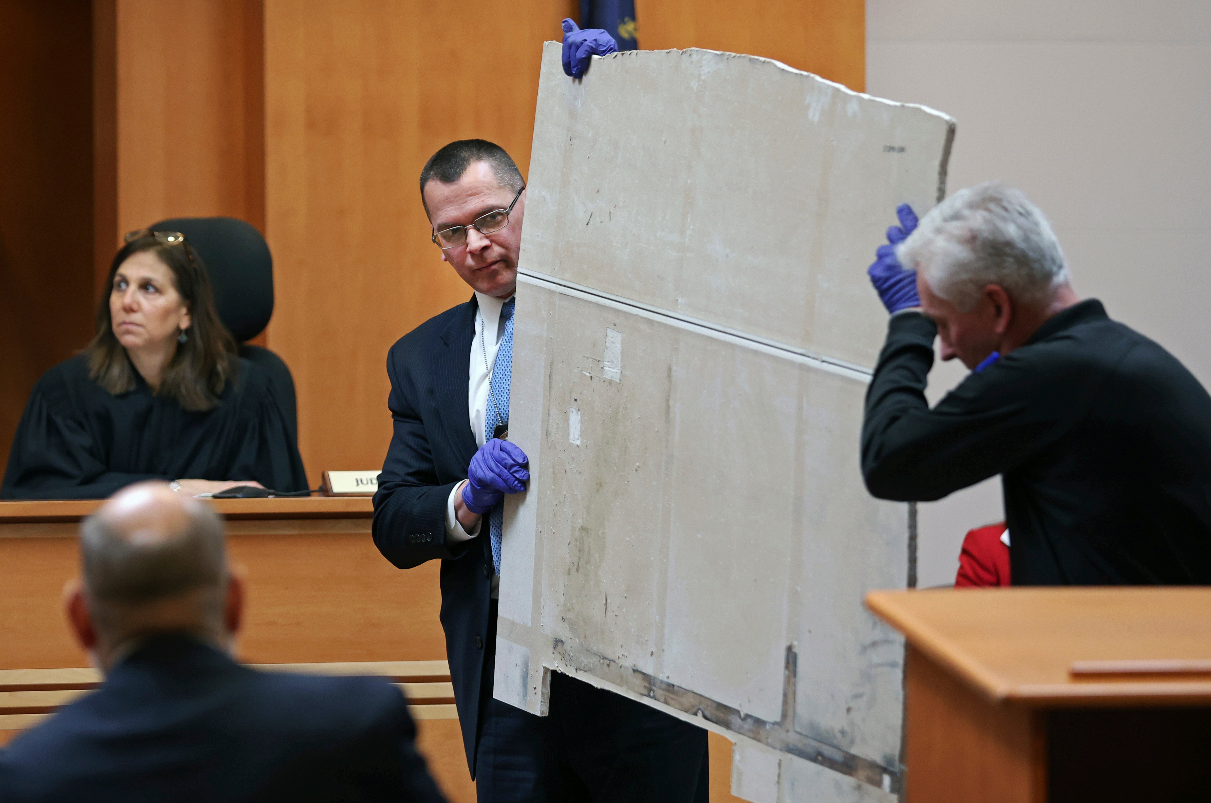 Manchester Police Detective Ray Lamy, left, and Evidence Technician Dave Dydo hold evidence during the trial of Adam Montgomery