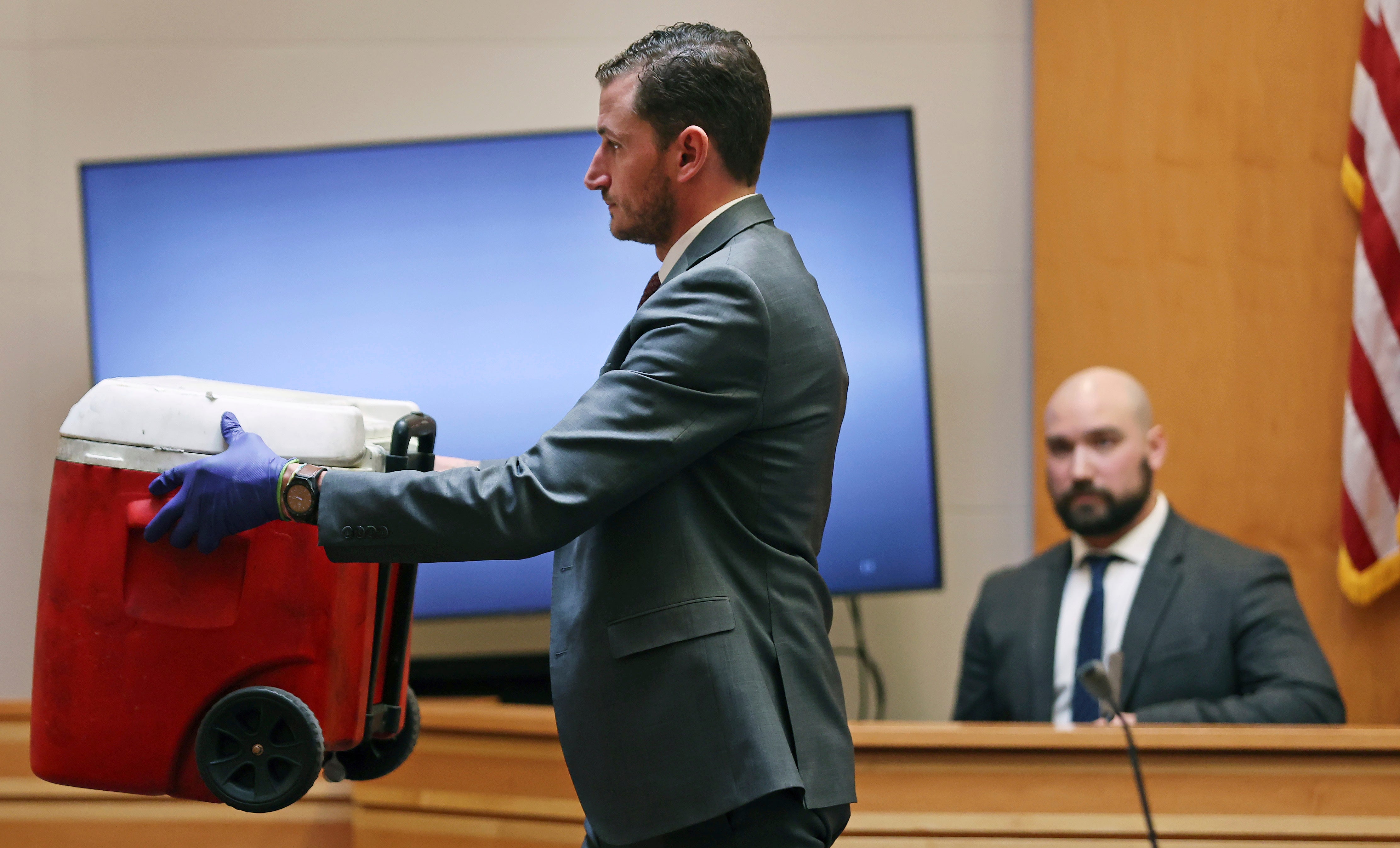 Assistant New Hampshire Attorney General Christopher Knowles shows a red cooler to the jury that had just been identified by witness Martin Orlowicz, a New Hampshire State Police Forensic Lab latent print examiner during Adam Montgomery's trial
