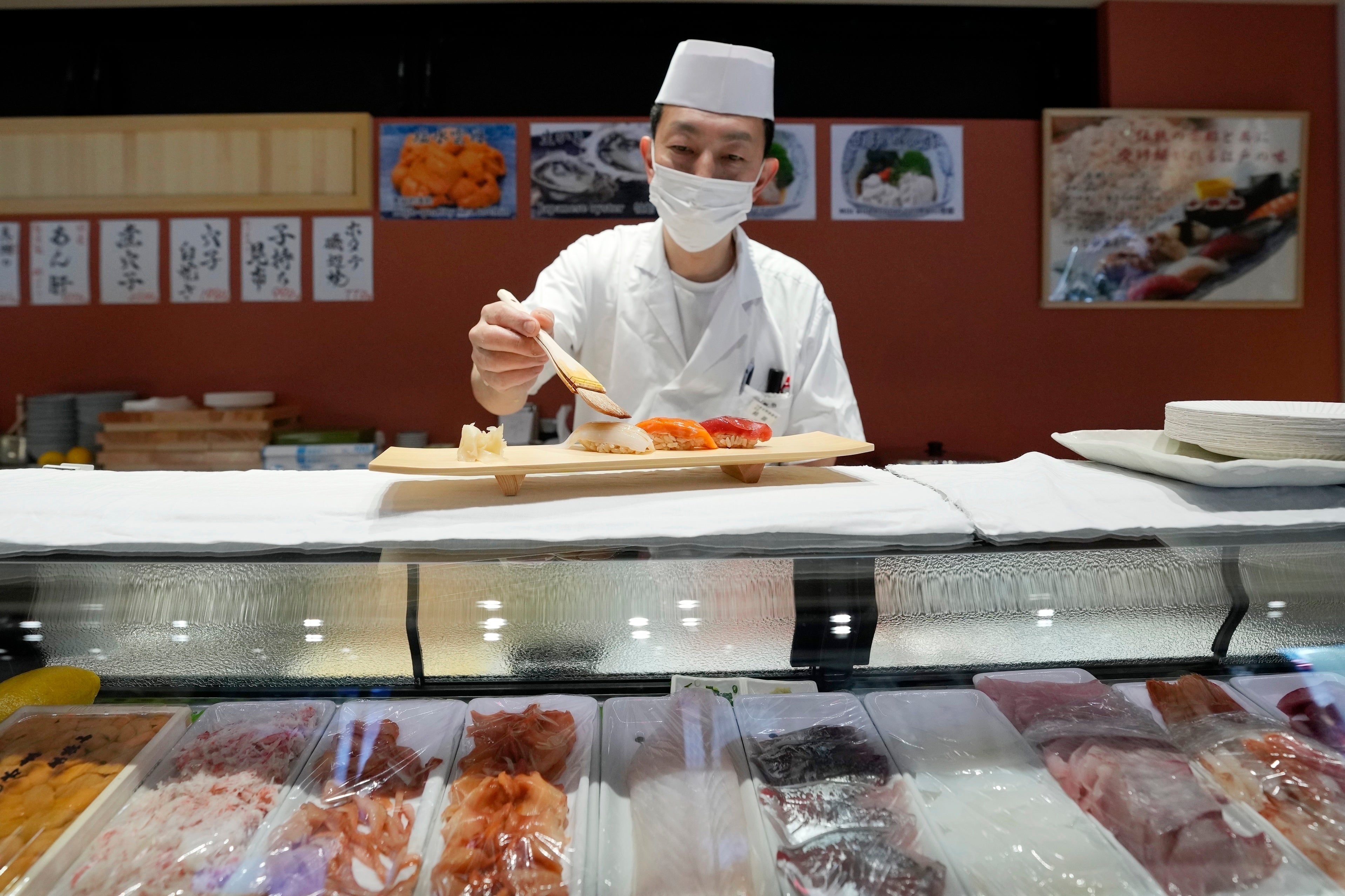 A sushi chef prepares a plate at the Toyosu Market Monday, January. 29, 2024, in Tokyo