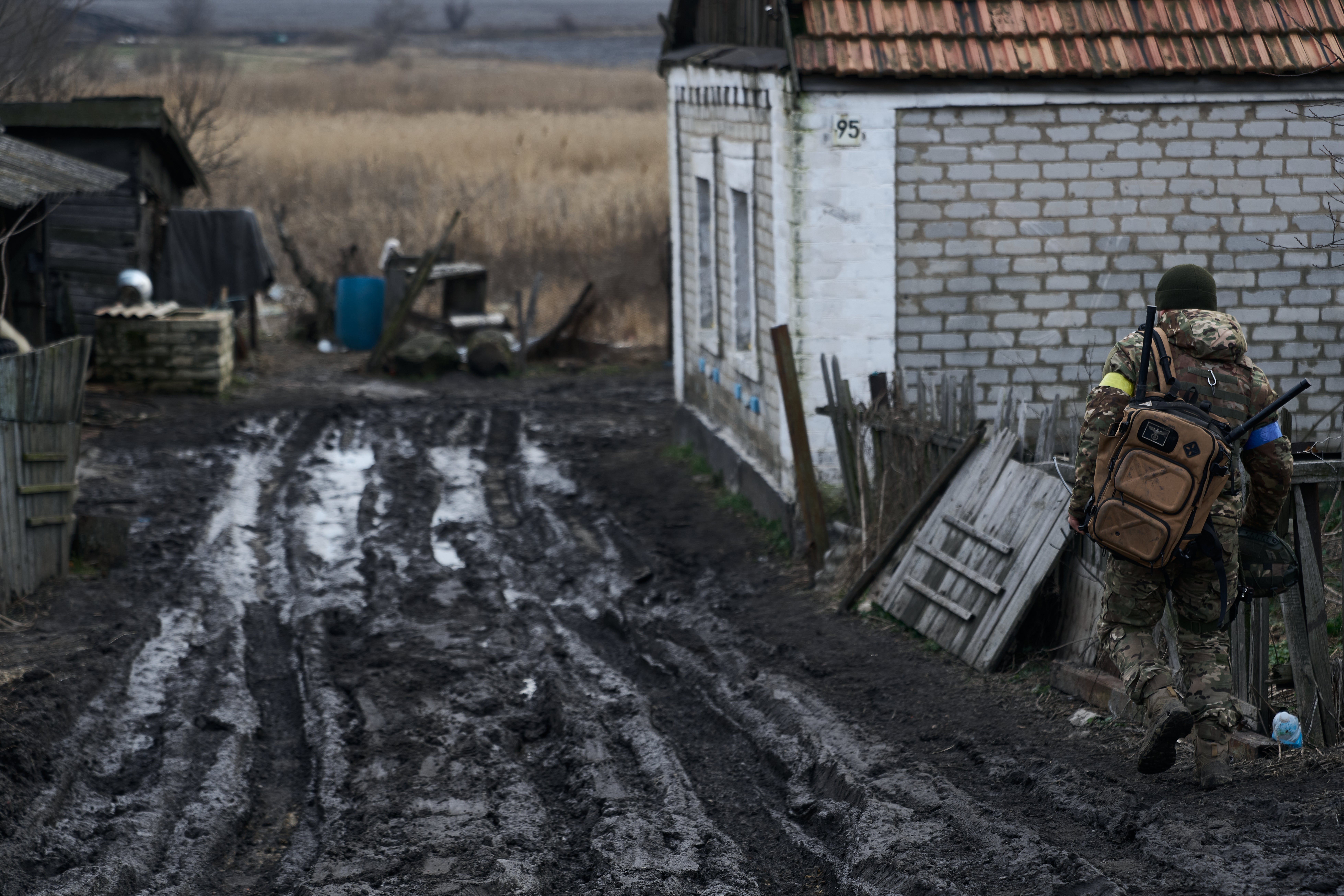 A soldier with a shoulder bag with a drone FPV jammer on the road to the city, on the outskirts of Avdiivka