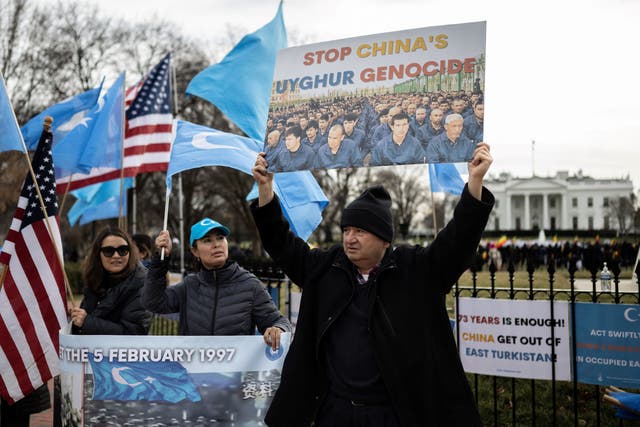 <p>People hold up flags and signs during a protest in Washington, DC on February 5, 2023, marking the 26th anniversary of the 1997 Ghulja massacre in Ghulja City, in the Xinjiang province of China</p>