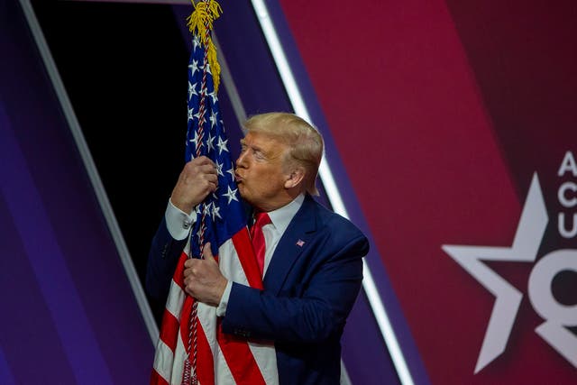 <p>Donald Trump kisses the flag of the United States of America at CPAC on 29 February 2020 </p>