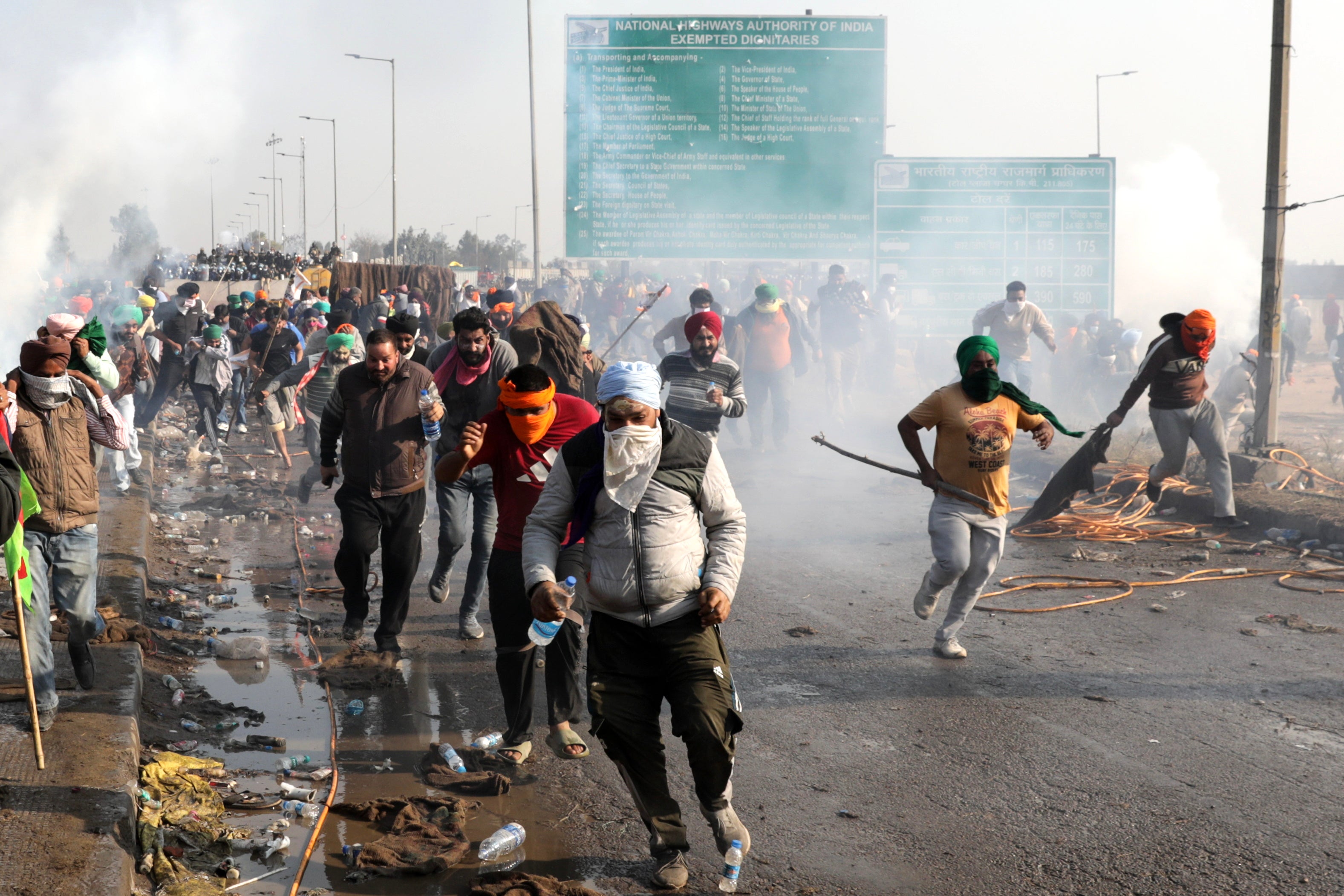 <p>Protesting farmers run for cover as Indian Police fires teargas to prevent them from moving towards Delhi on the second day of their protest at Shambhu Haryana-Punjab border point</p>