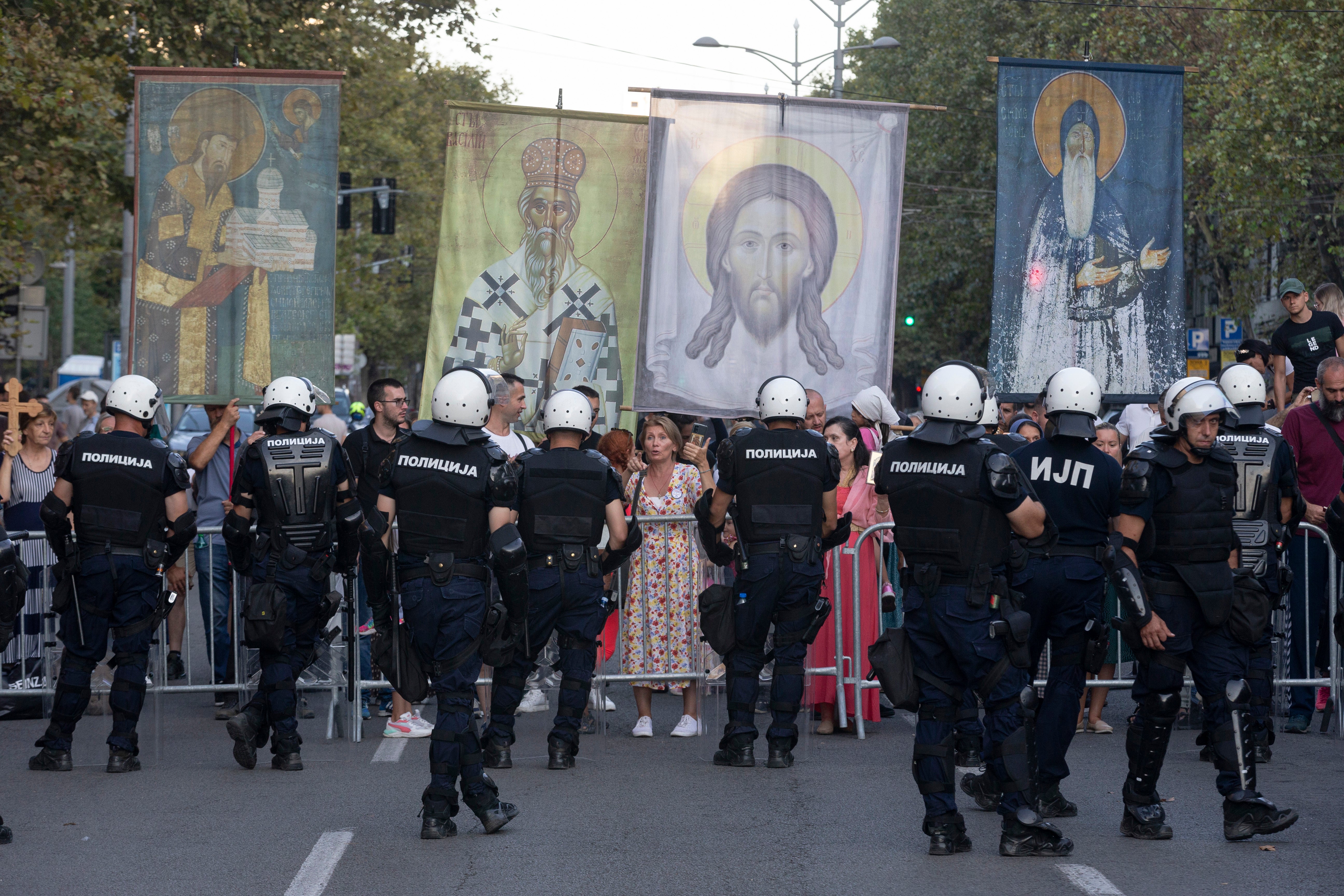 FILE - Anti-gay protesters hold religious banners amid heavy police presence and during a Pride march in Belgrade, Serbia