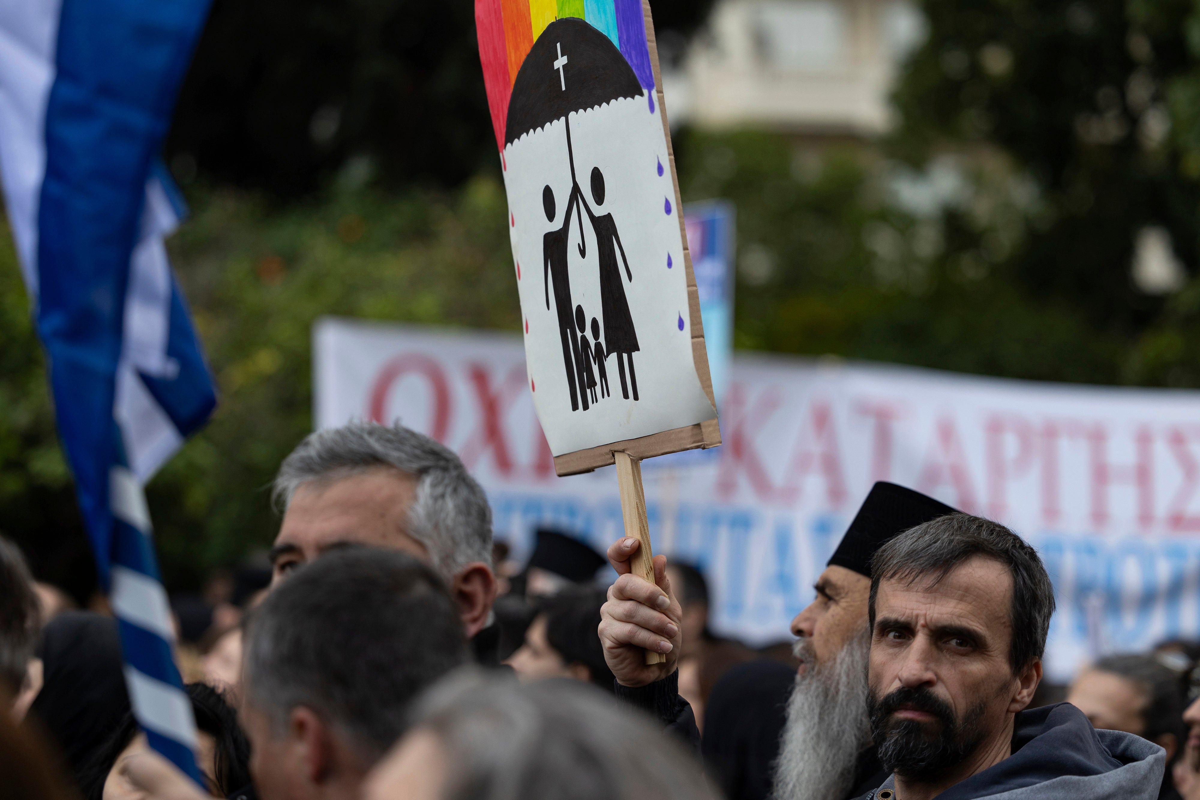 FILE - A protester raises a banner during a rally against same-sex marriage, at central Syntagma square, in Athens