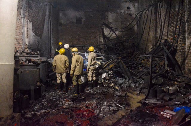 <p>Fire brigade personnel look on after dousing a late Thursday fire at a paint factory in the Alipur area in northern New Delhi, India, Friday, 16 February 2024</p>