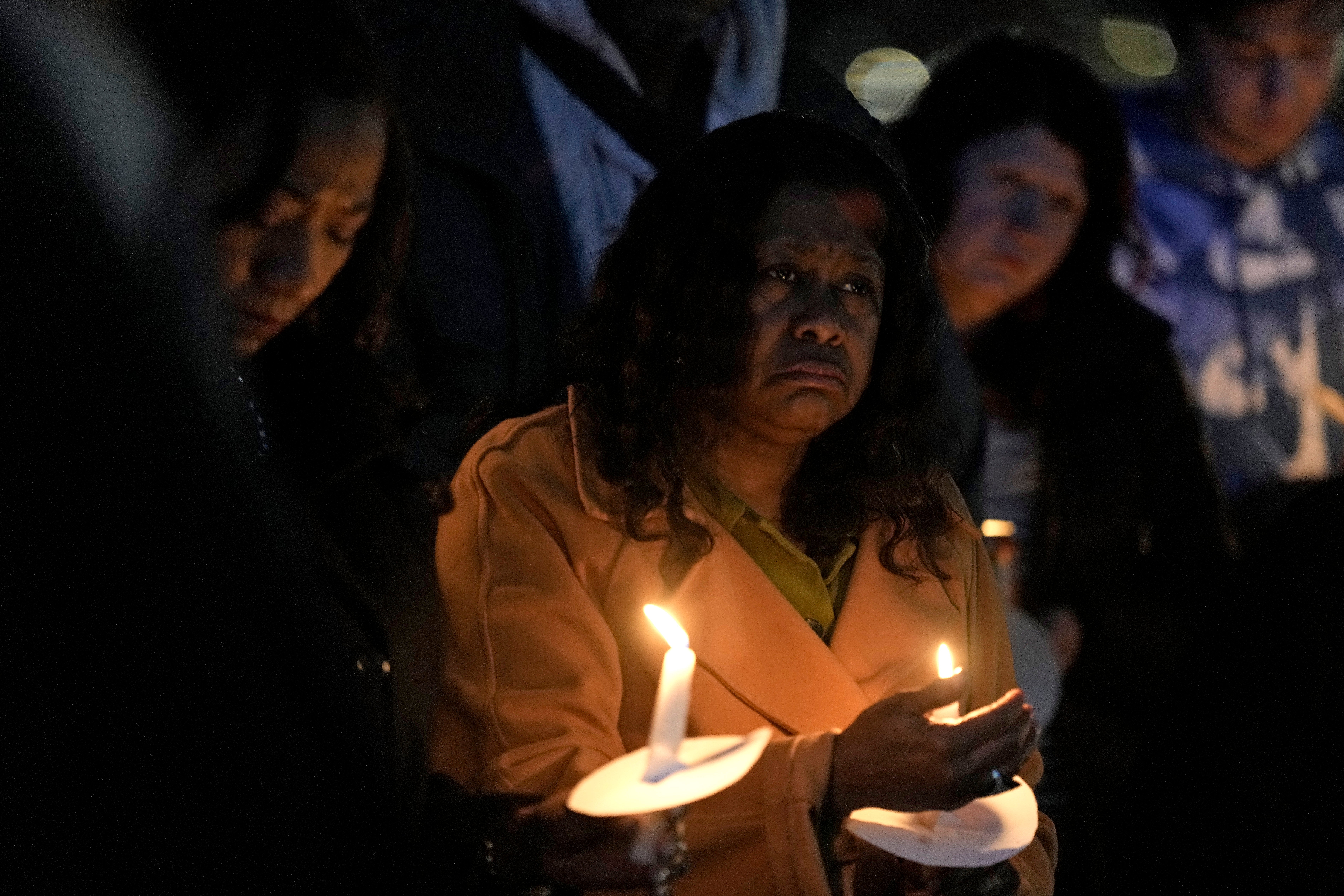 A woman holds a candle at the Kansas City, Missouri vigil