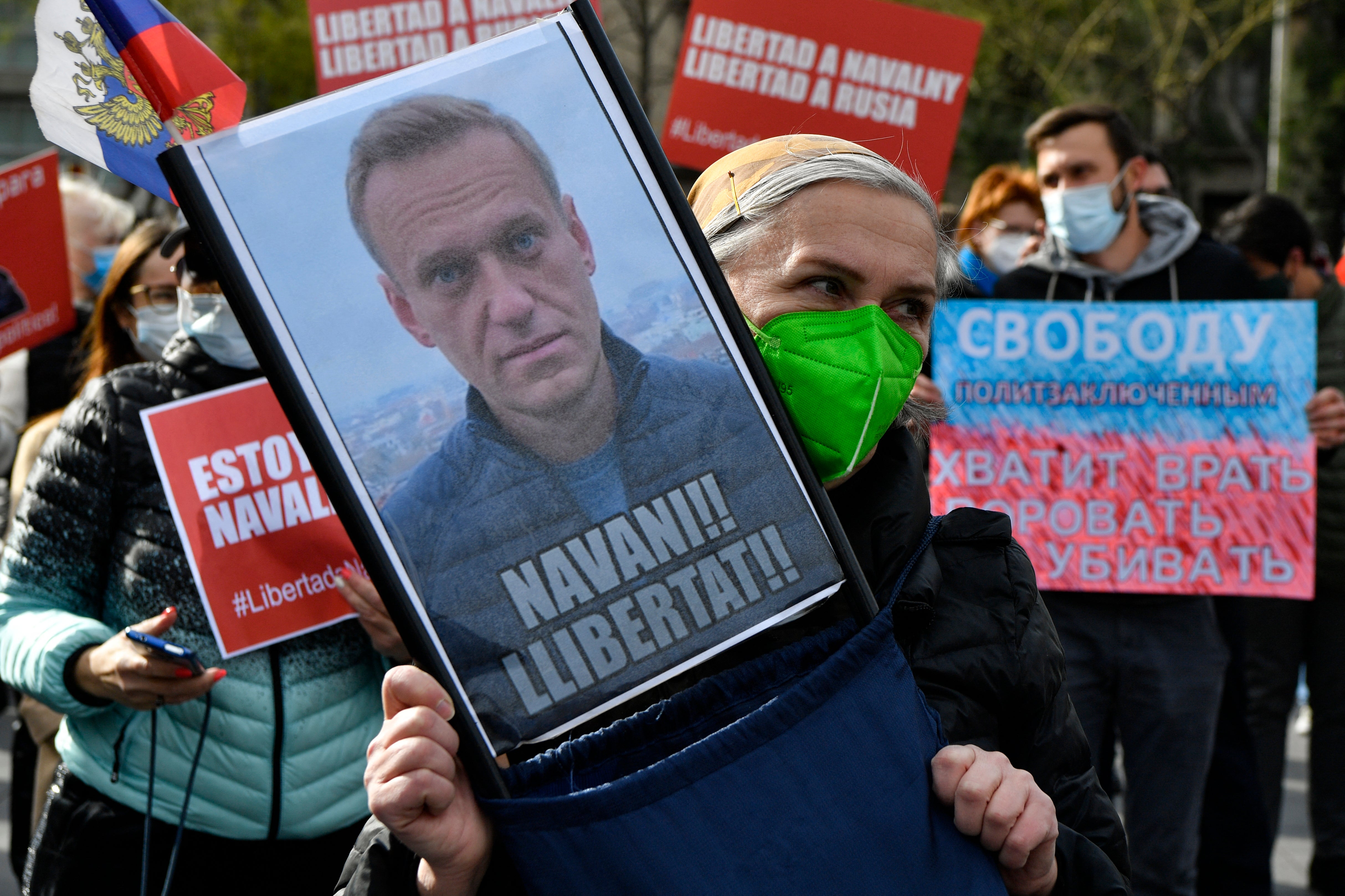 A woman holds a picture of detained Russian opposition leader Alexei Navalny reading "Free Navalny!" during a demonstration in Barcelona