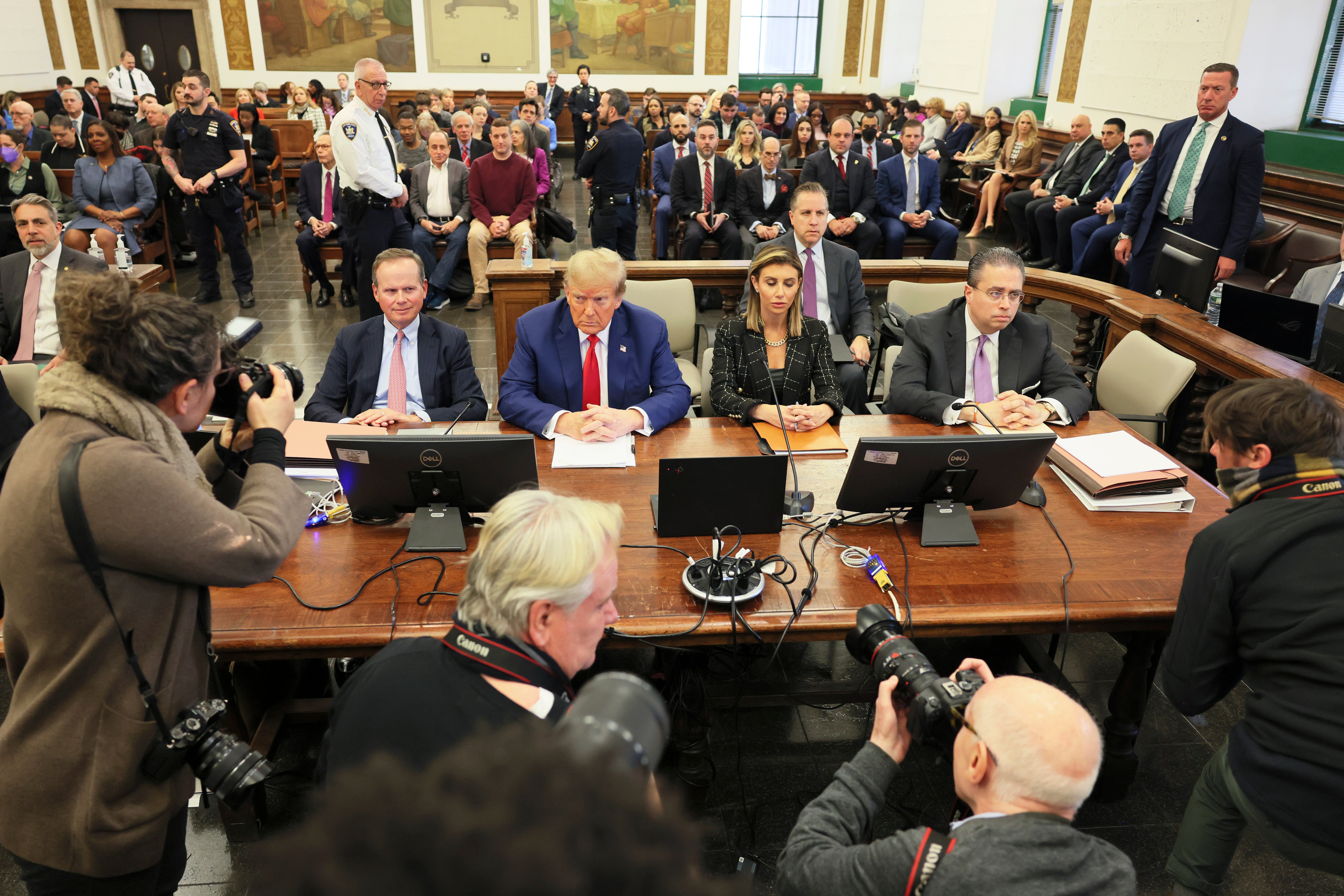 Photographers surround Donald Trump and his attorneys before closing arguments in a civil fraud case in New York on 11 January.