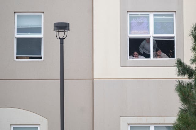 <p>Students look outside their dorm window in the Village at Alpine Valley housing, as police investigate a shooting on the University of Colorado Colorado Springs campus</p>