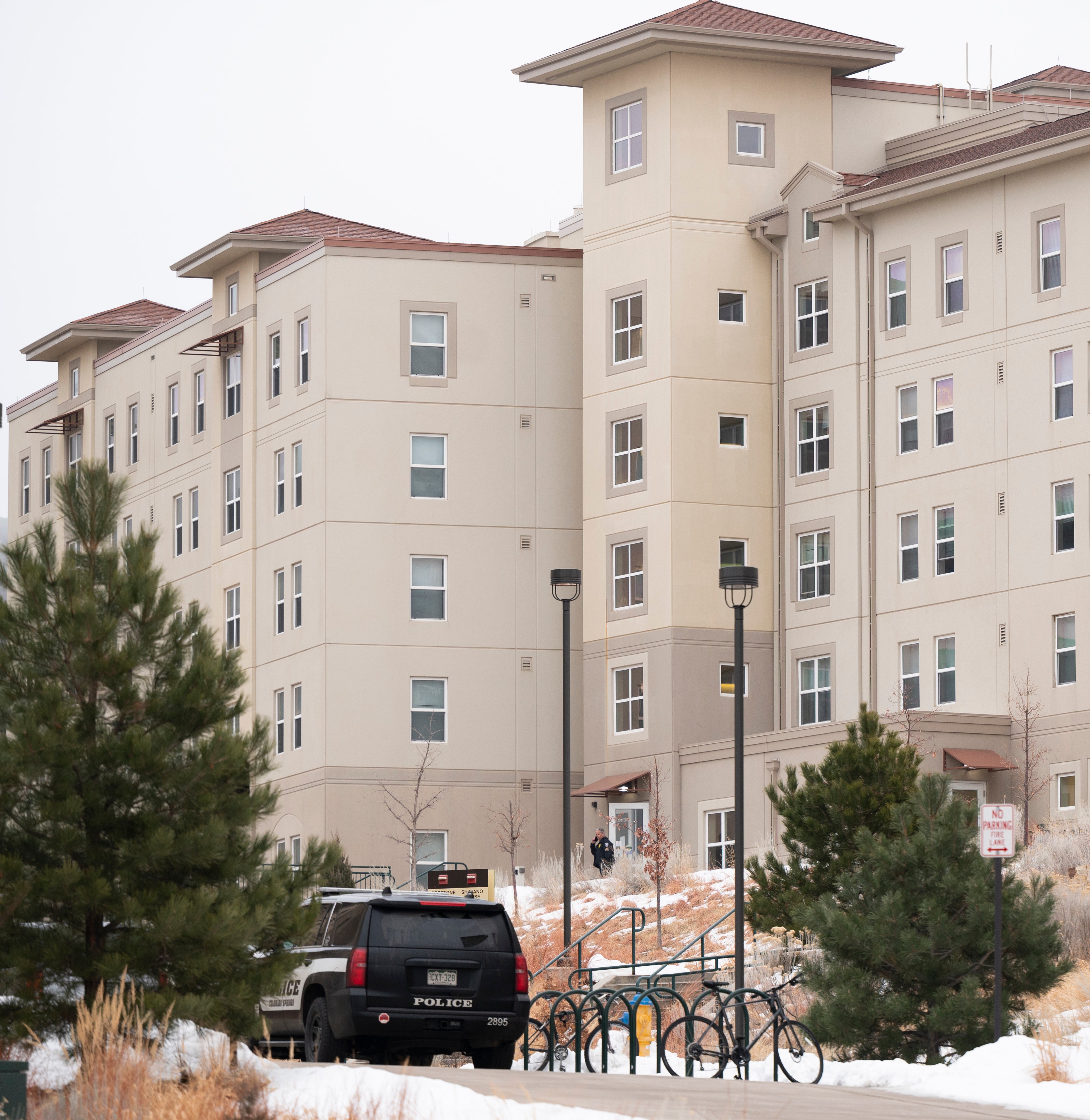 A police officer stands outside a dorm in the Village at Alpine Valley housing, Friday 16 February 2024, as police investigate a shooting on the University of Colorado Colorado Springs campus in Colorado Springs, Colo. (Christian Murdock/The Gazette via AP)