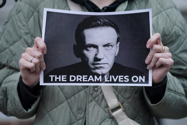 A protester holds a picture of Alexei Navalny at a protest opposite the Russian embassy in London on Friday (Jonathan Brady/PA)