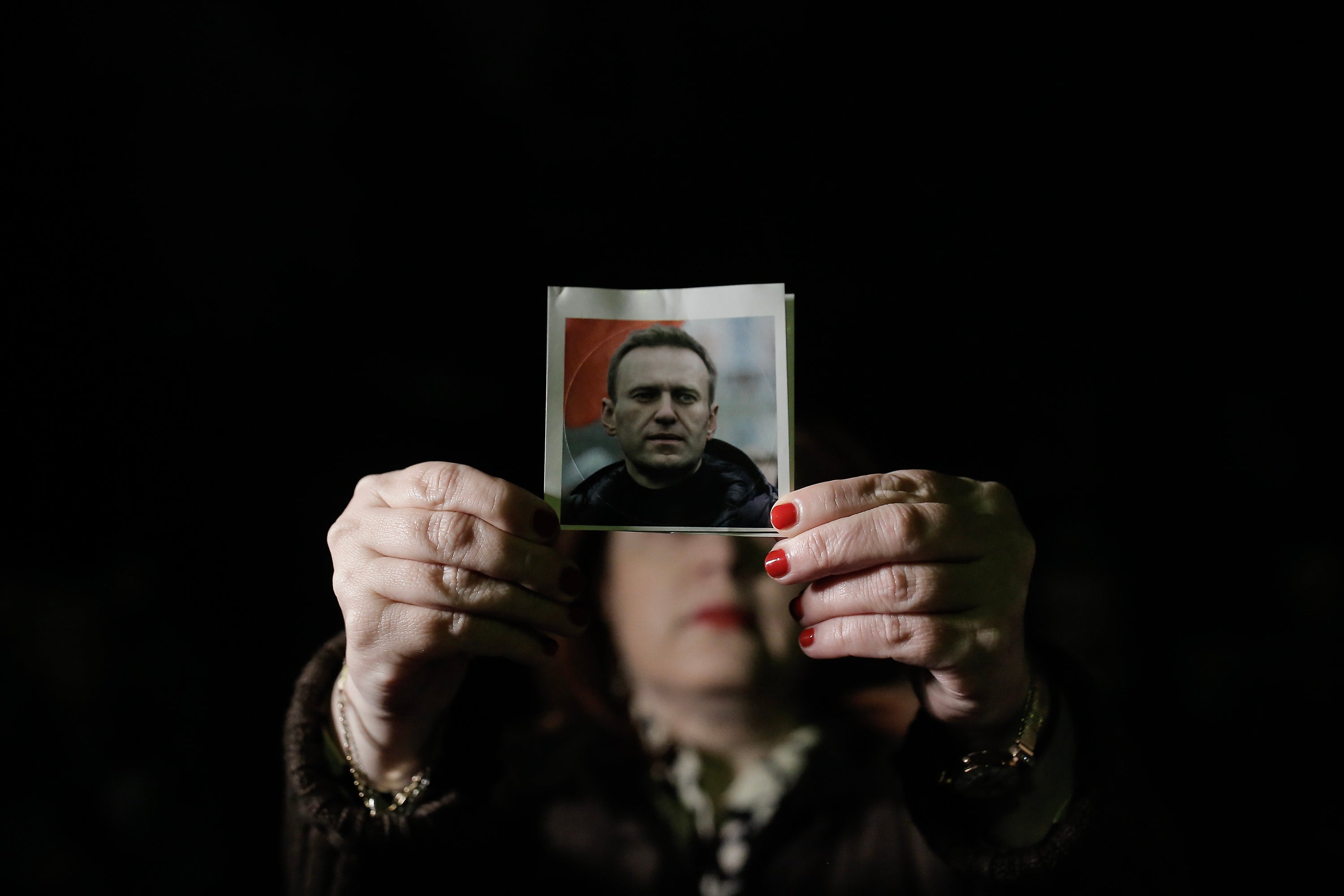 <p> A protester holding a photo of late Russian opposition leader Alexei Navalny attends a rally to commemorate his death, outside the Russian Embassy in Athens, Greece, 19 February 2024</p>