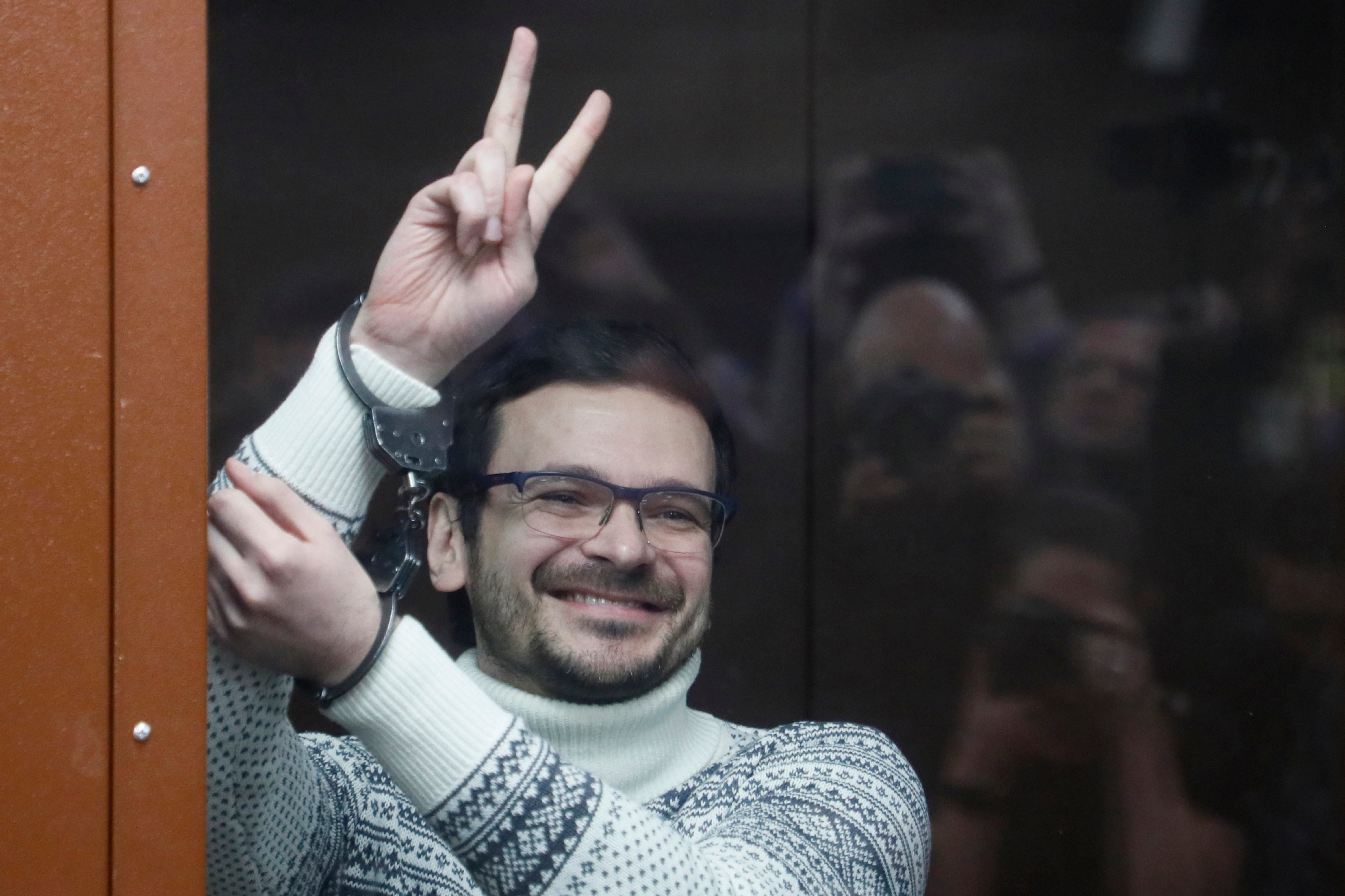 <p>Russian opposition activist and former municipal deputy of the Krasnoselsky district Ilya Yashin gestures, smiling, as he stands in a defendant's cubicle in a courtroom, prior to a hearing in Moscow, Russia, on Dec. 9, 2022</p>