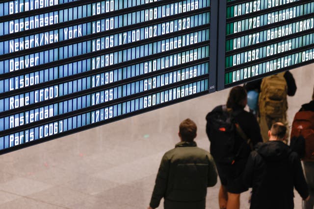 <p>Passengers check a flight information board flight during a strike action by ground crews, services staff and security personnel, at Munich International Airport in Munich</p>