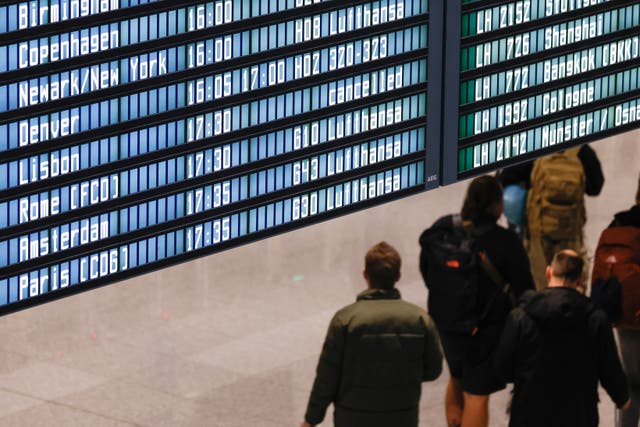 <p>Passengers check a flight information board flight during a strike action by ground crews, services staff and security personnel, at Munich International Airport in Munich</p>