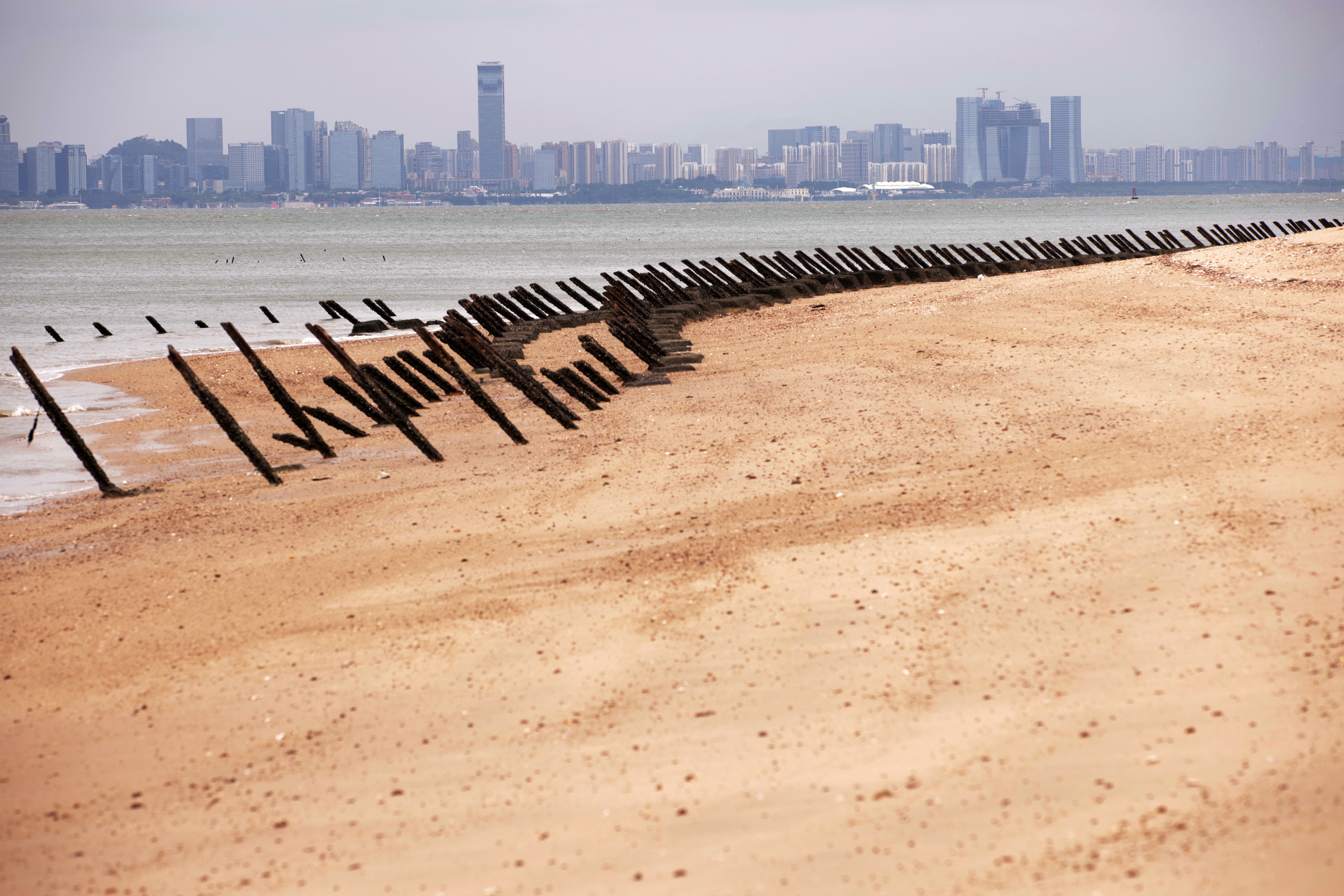 As the city of Xiamen, China, is seen in the background, wartime anti-tank obstacles sit on a beach on 7 October 2023 in Kinmen