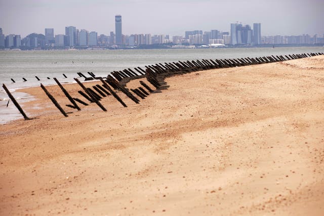 <p>File. As the city of Xiamen, China, is seen in the background, wartime anti-tank obstacles sit on a beach on 7 October 2023 in Kinmen Island </p>