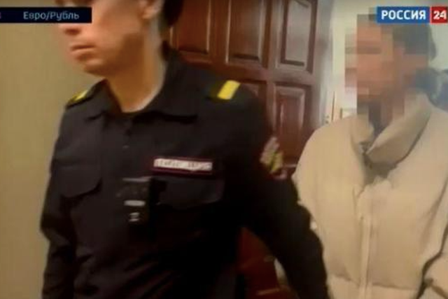 <p>A screengrab from a video aired on 20 February 2024 by Russia’s state-run broadcaster RU24 shows an LA woman being arrested and taken to court in Russia</p>