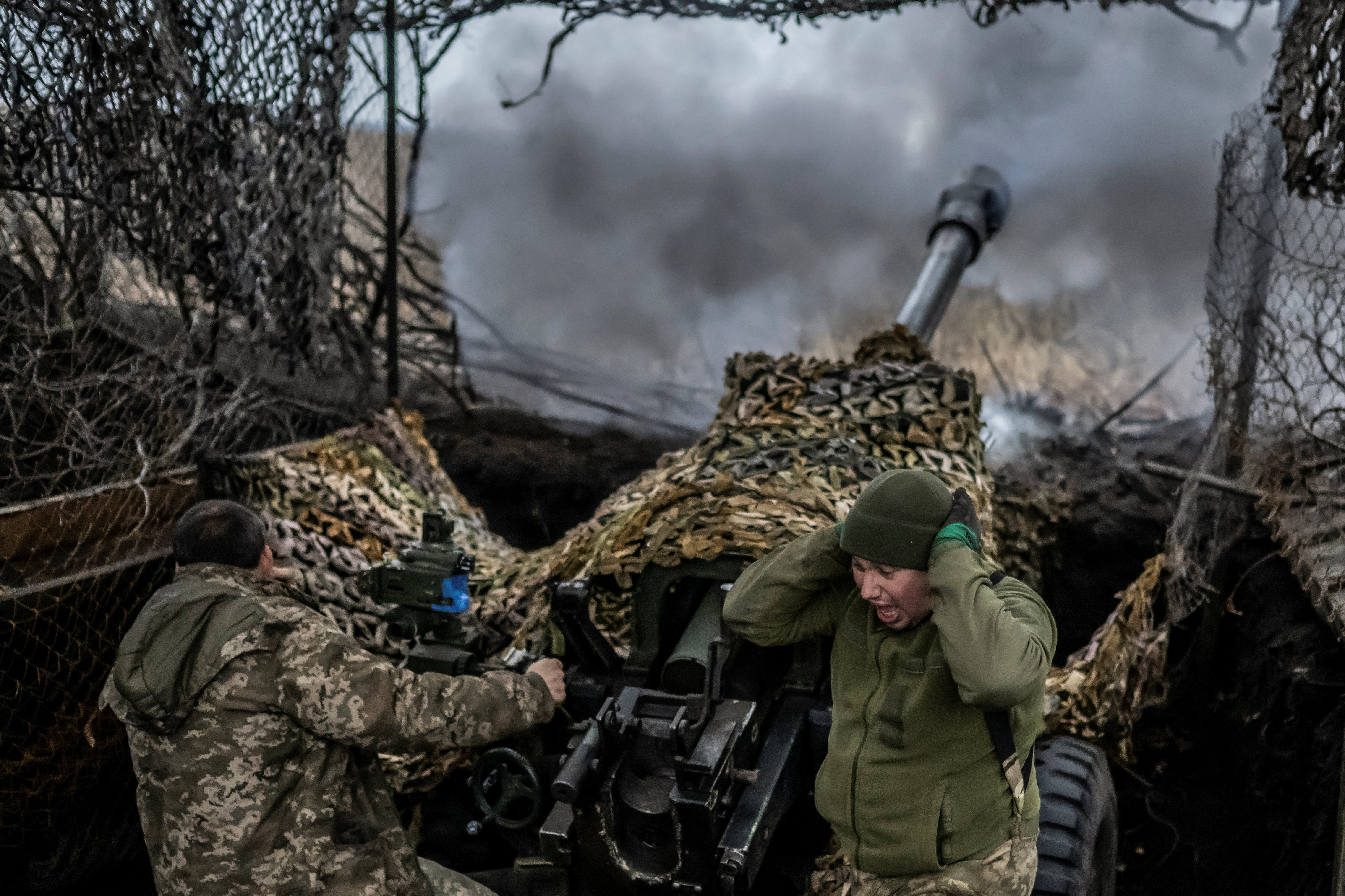 Ukrainian service members fire an L119 howitzer towards Russian troops near the front-line town of Bakhmut