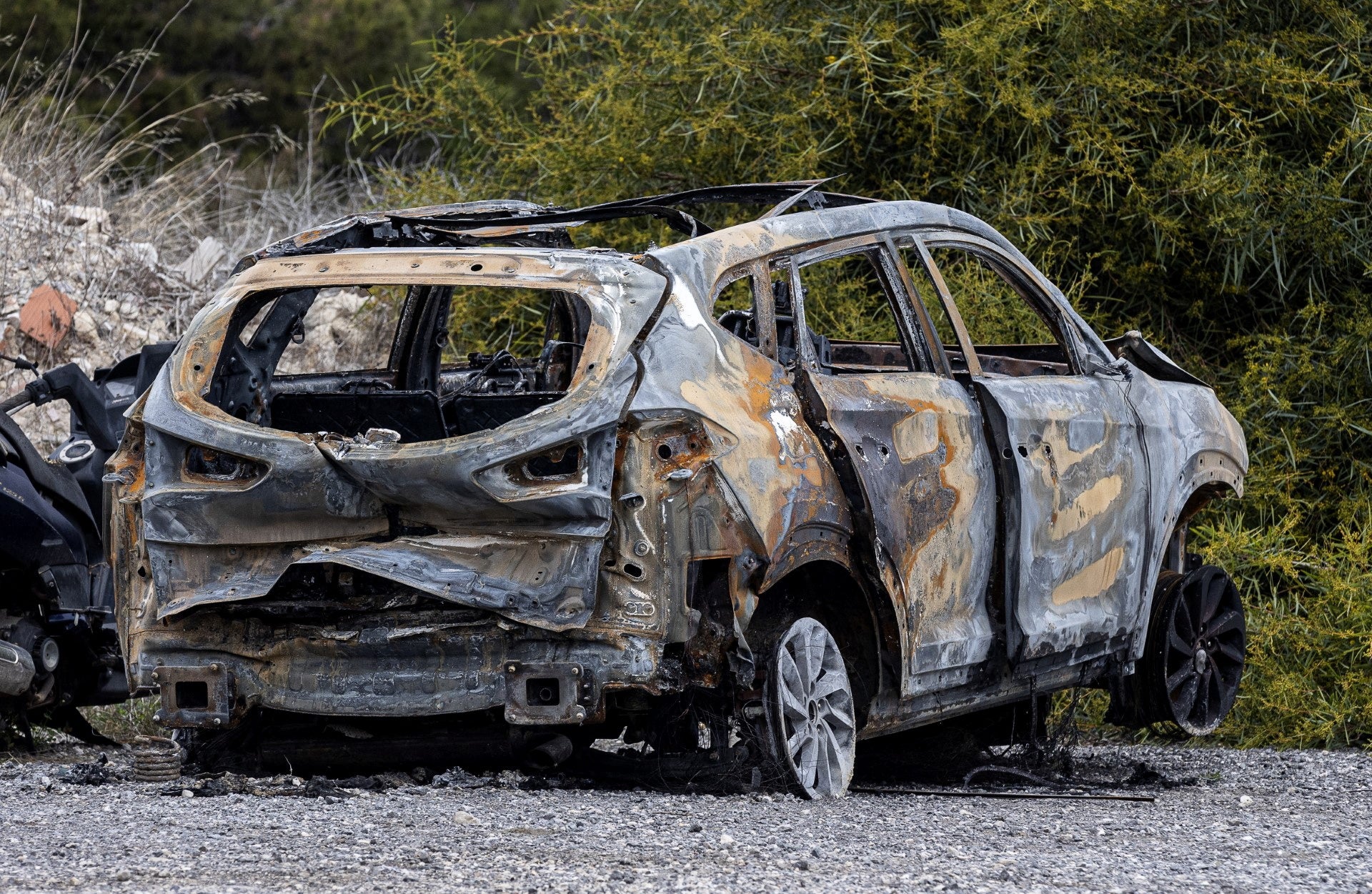 A burned car allegedly used by the killers to escape the scene is parked outside the Guardia Civil barracks, in El Campello