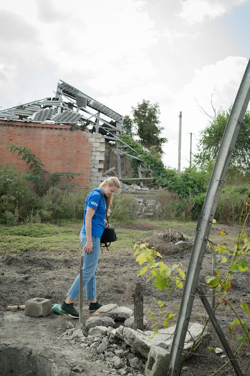 A WFP inspector looks for mines and dangerous debris in a garden in Kamianka